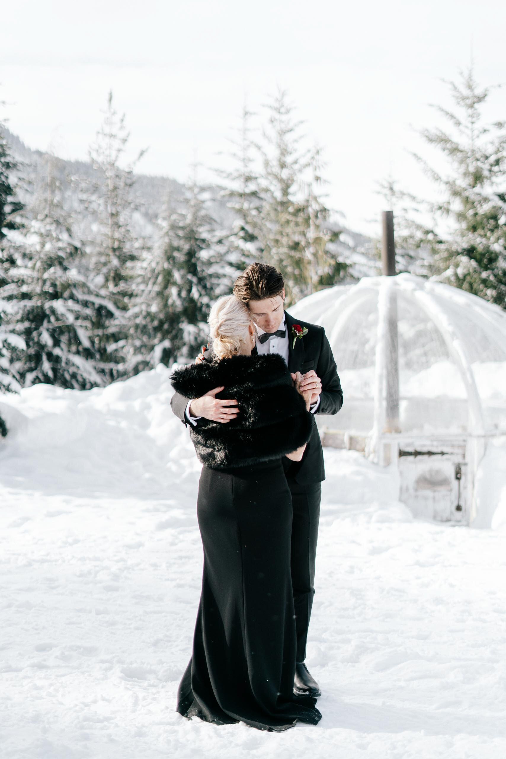 A groom hugs his mom in the snow during his Whistler wedding.