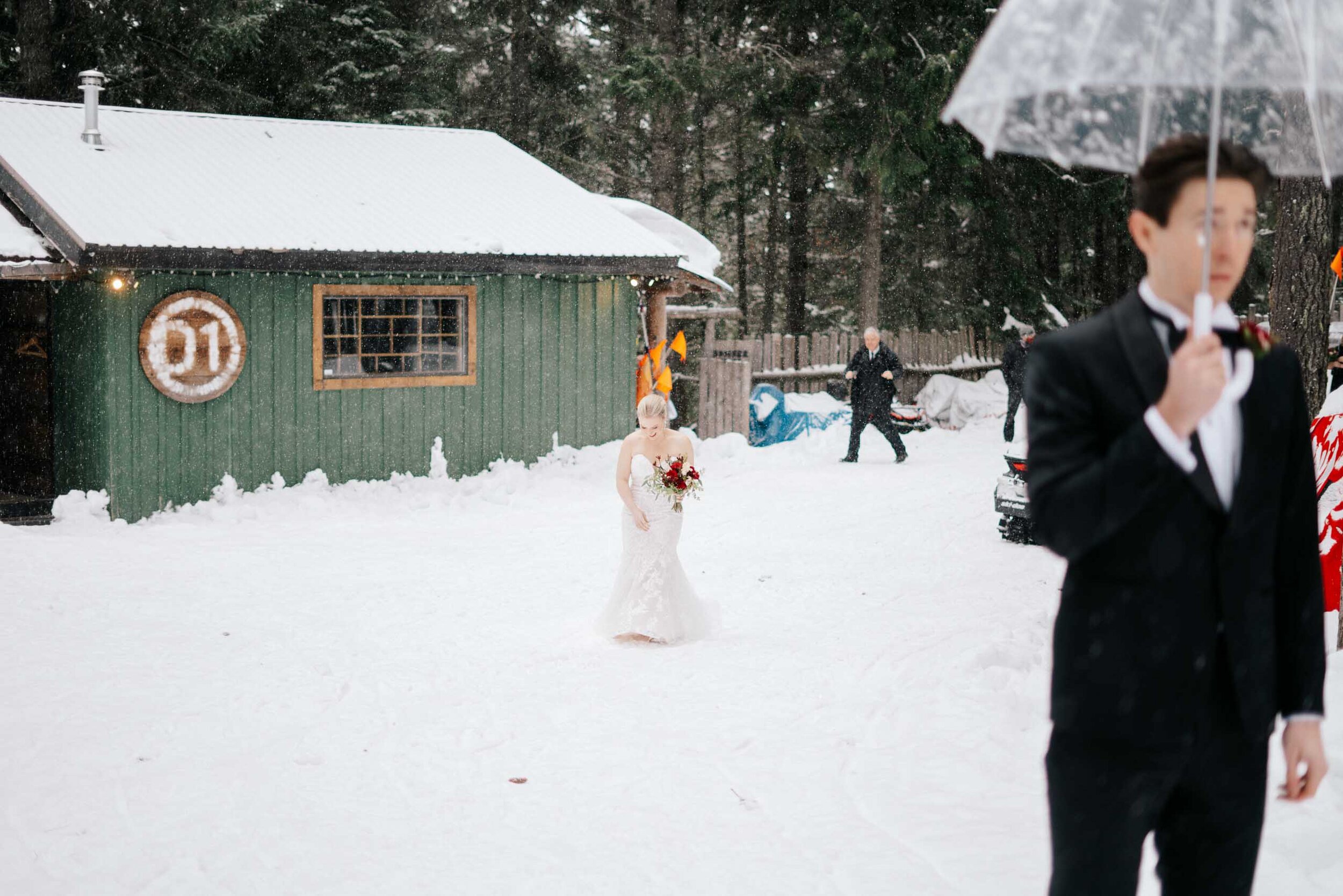 A beautiful pale bride approaches her groom through the snow. 