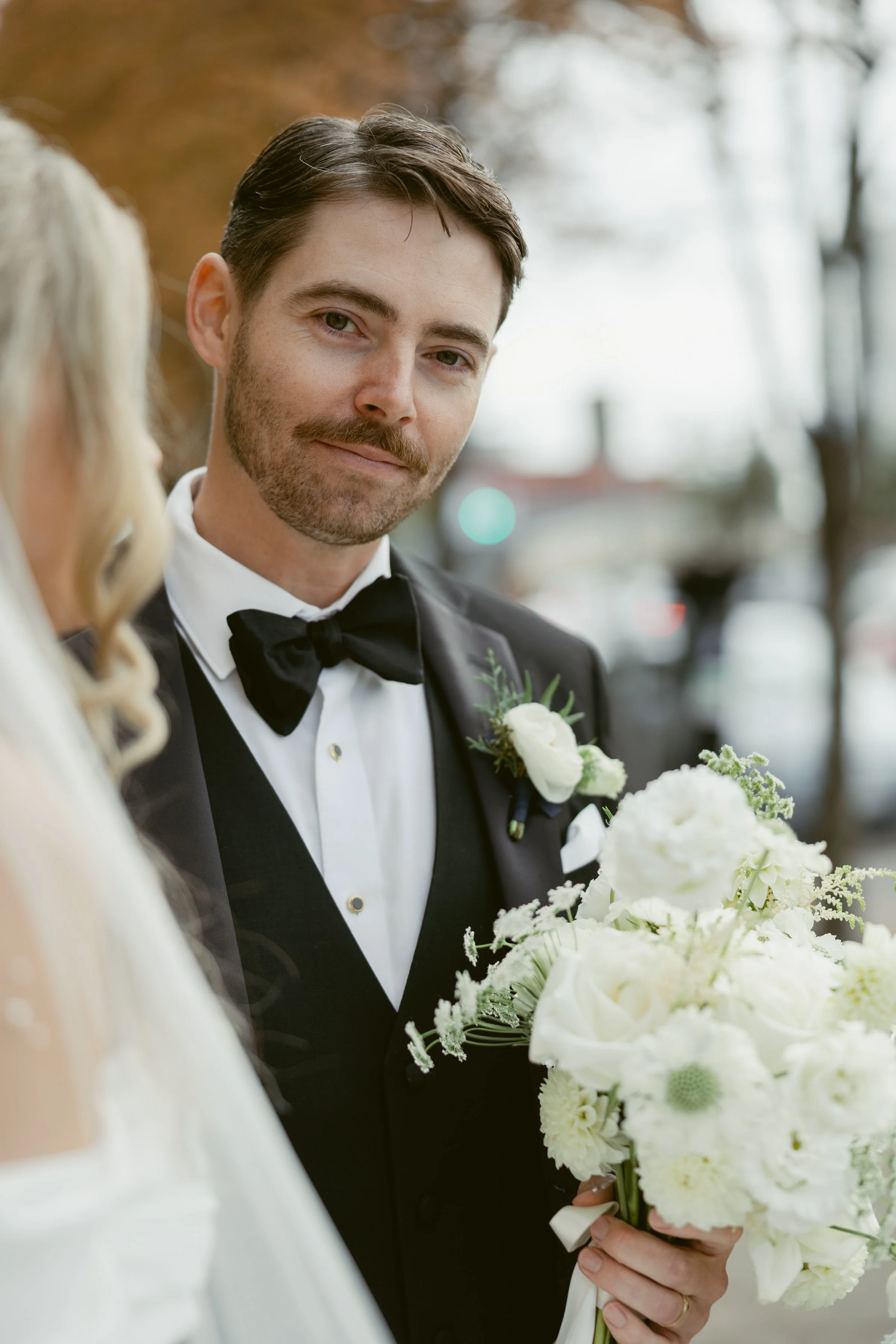 Groom holding his bride's bouquet, photographed by a Vancouver wedding photographer.