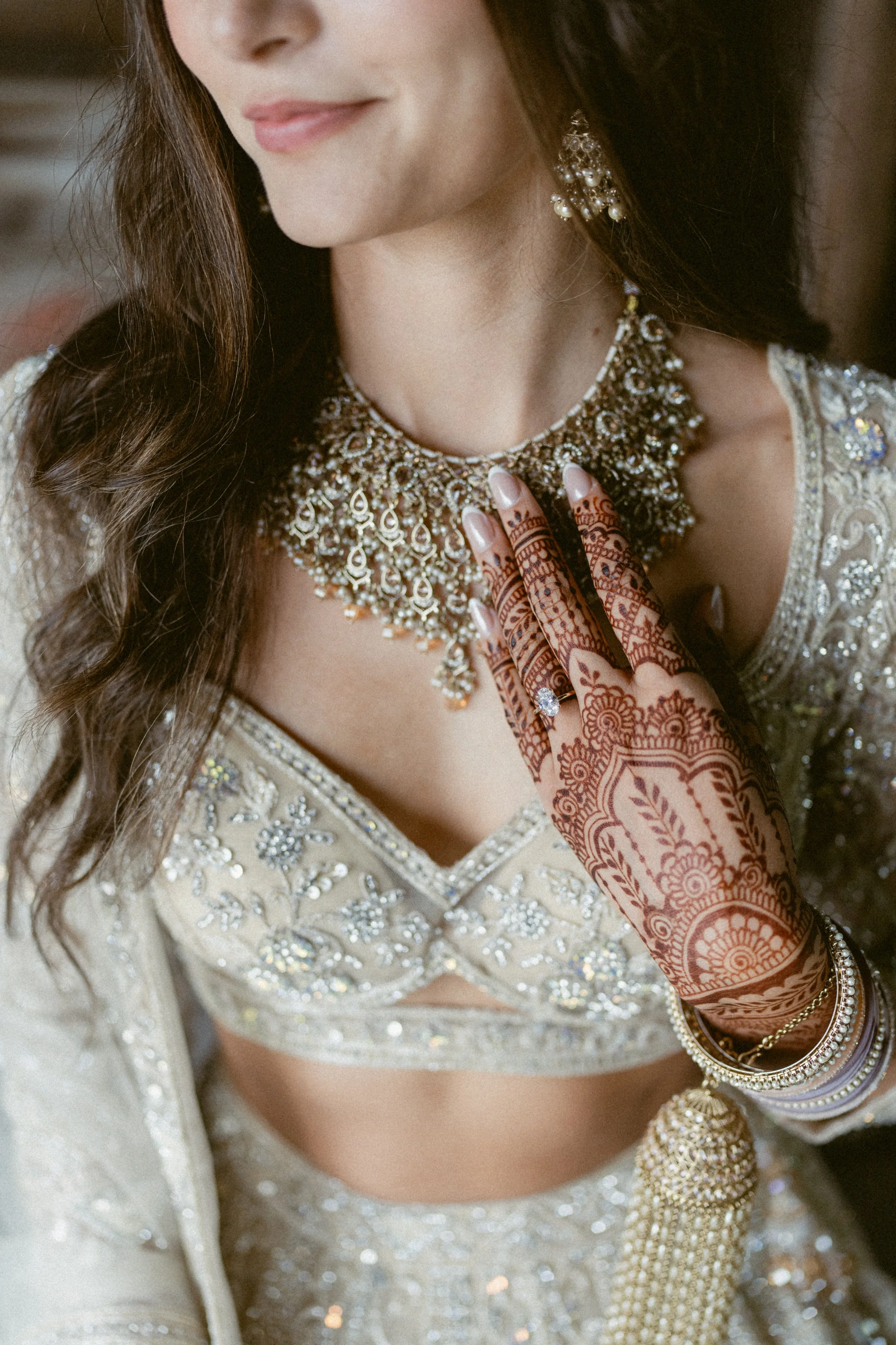 A bride showcasing henna and jewelry while getting ready for her wedding.