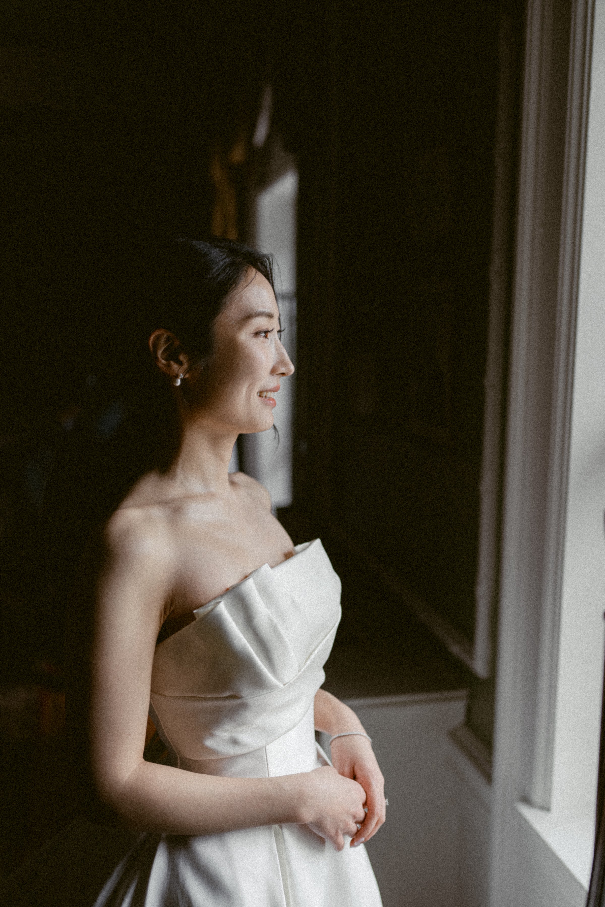 Bride standing by a window in soft natural light at Hycroft Manor.