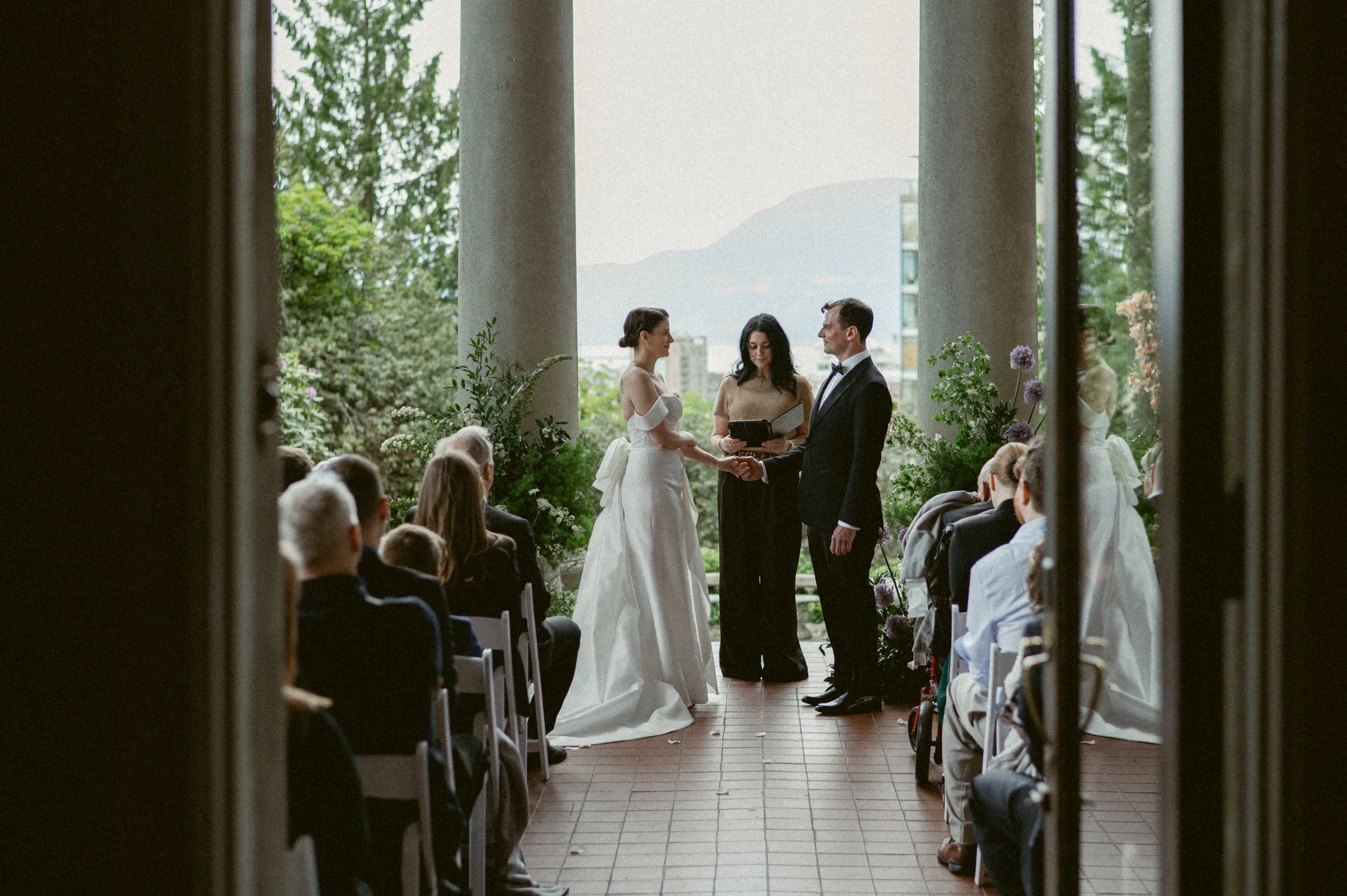 Outdoor wedding ceremony at Hycroft Manor with guests seated between stone columns.