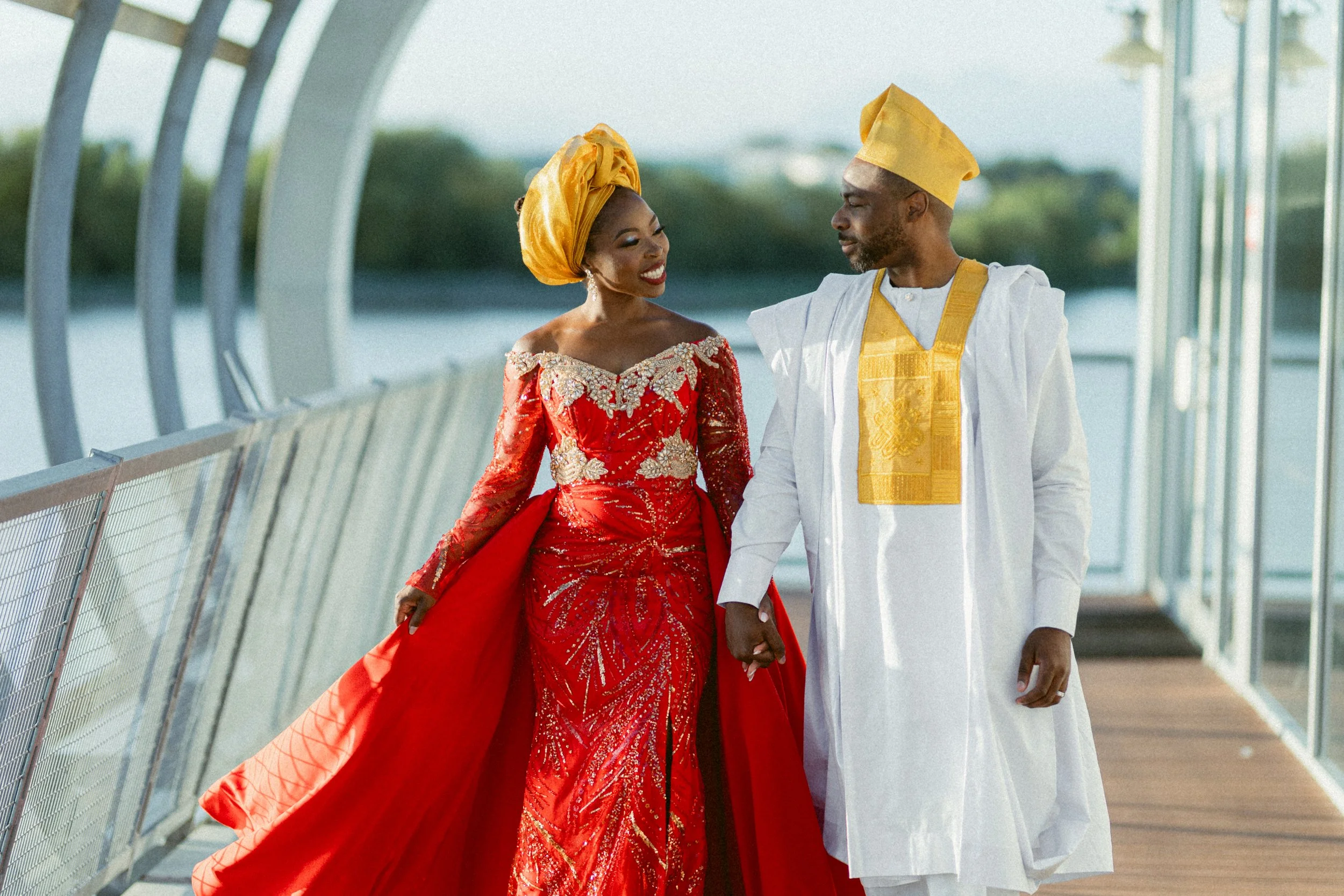 Couple in traditional Nigerian wedding attire walking hand in hand at the UBC Boathouse in Vancouver.