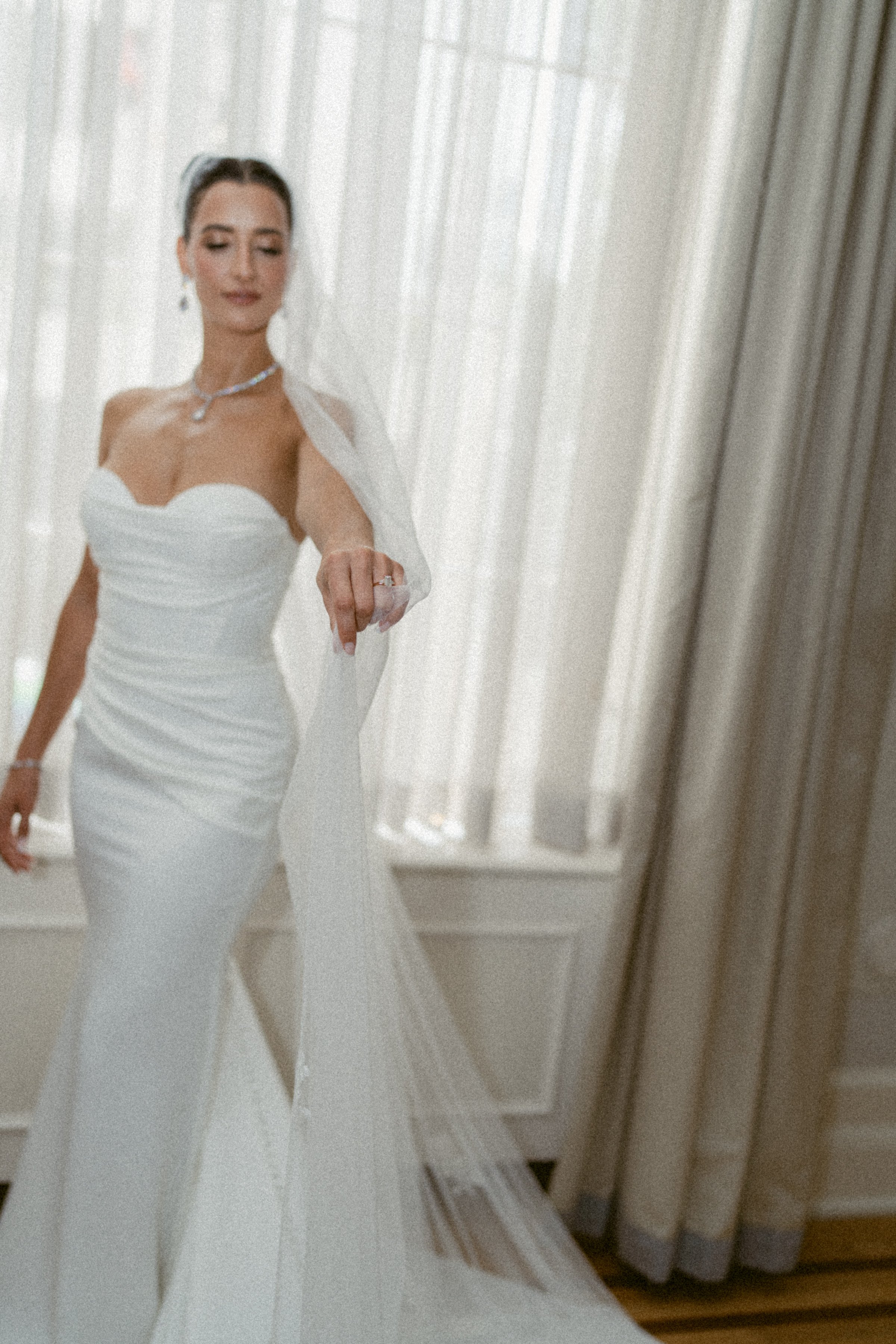 Bride adjusting her veil during bridal portraits at the Vancouver Club.