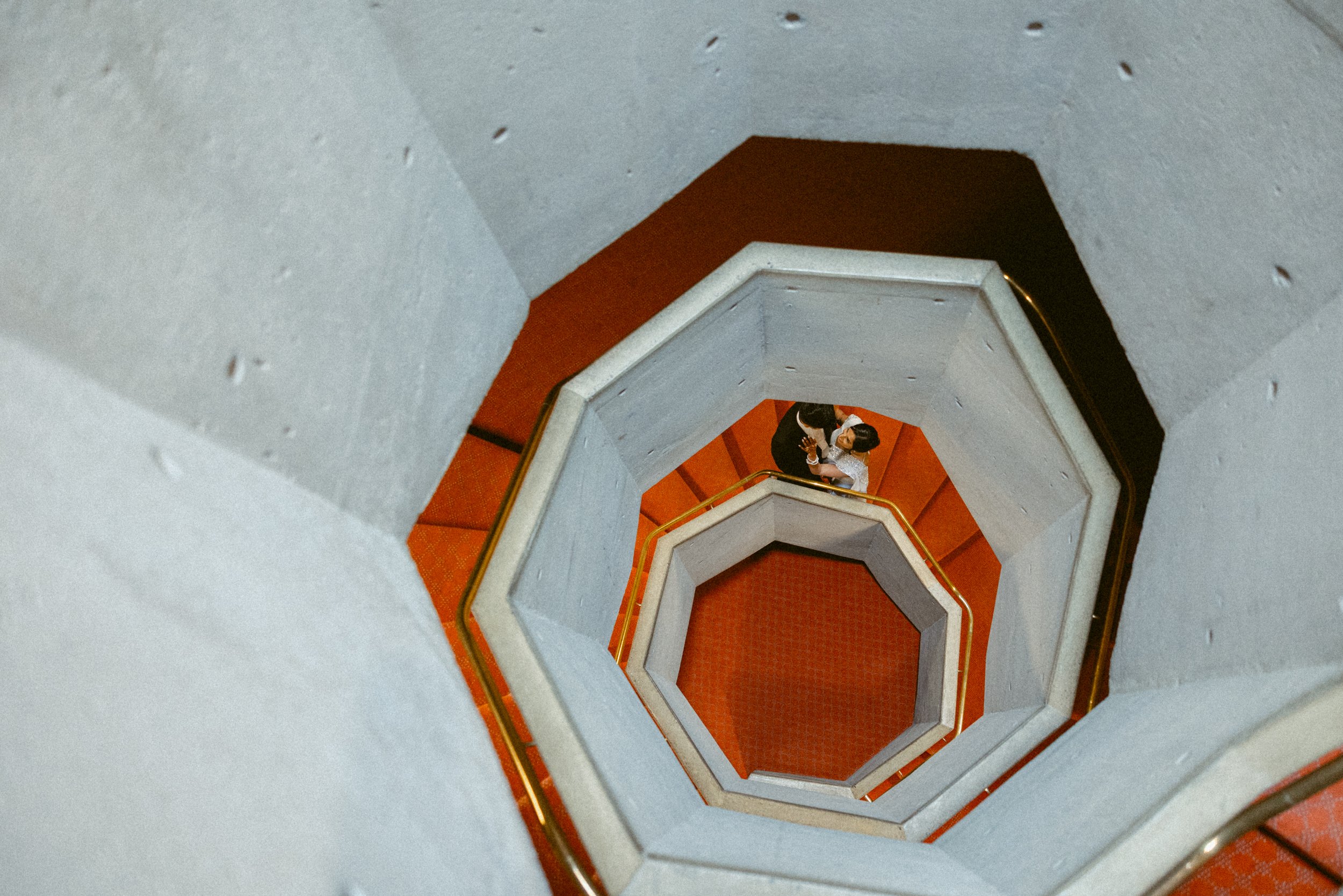 A bird's eye view of a bride and groom in a spiral staircase, photographed by a Vancouver wedding photographer.