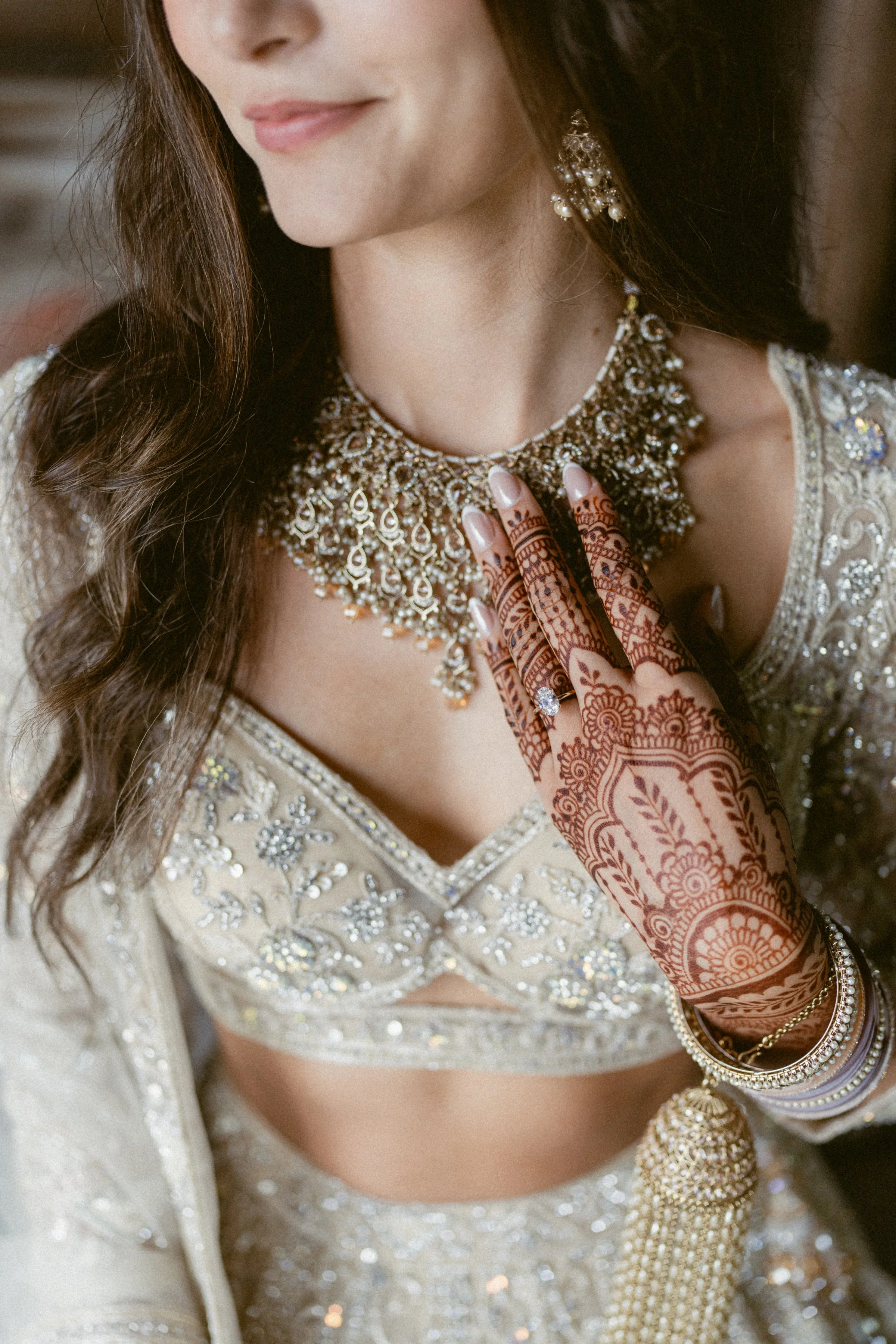 A bride showcasing henna and jewelry while getting ready for her wedding.