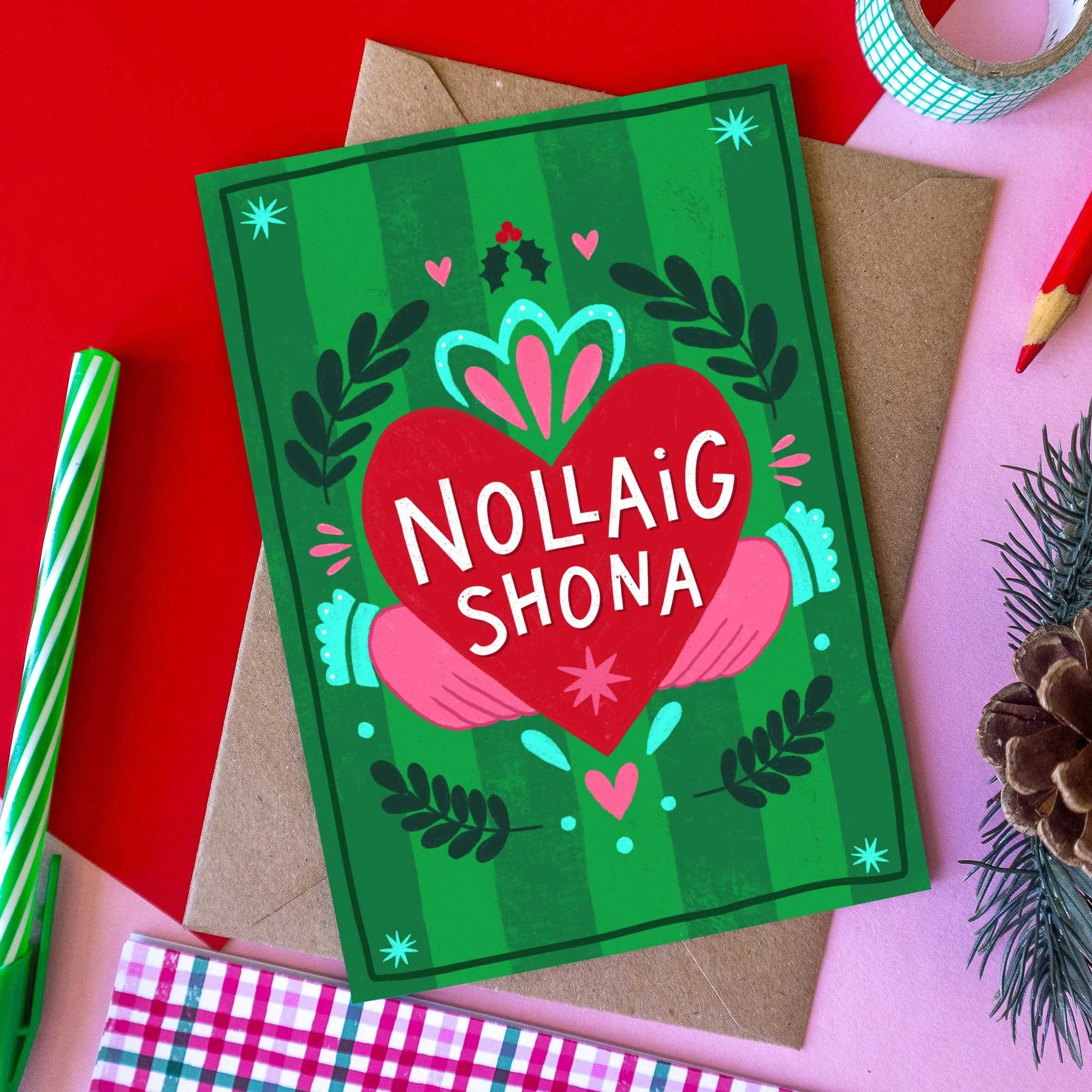 Irish Christmas card with Nollaig Shona Duit greeting, red Claddagh heart, hands and colourful green background