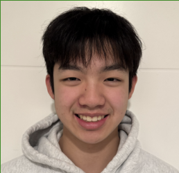 A young man with straight black hair wearing a light gray hoodie, smiling at the camera, against a plain white background.