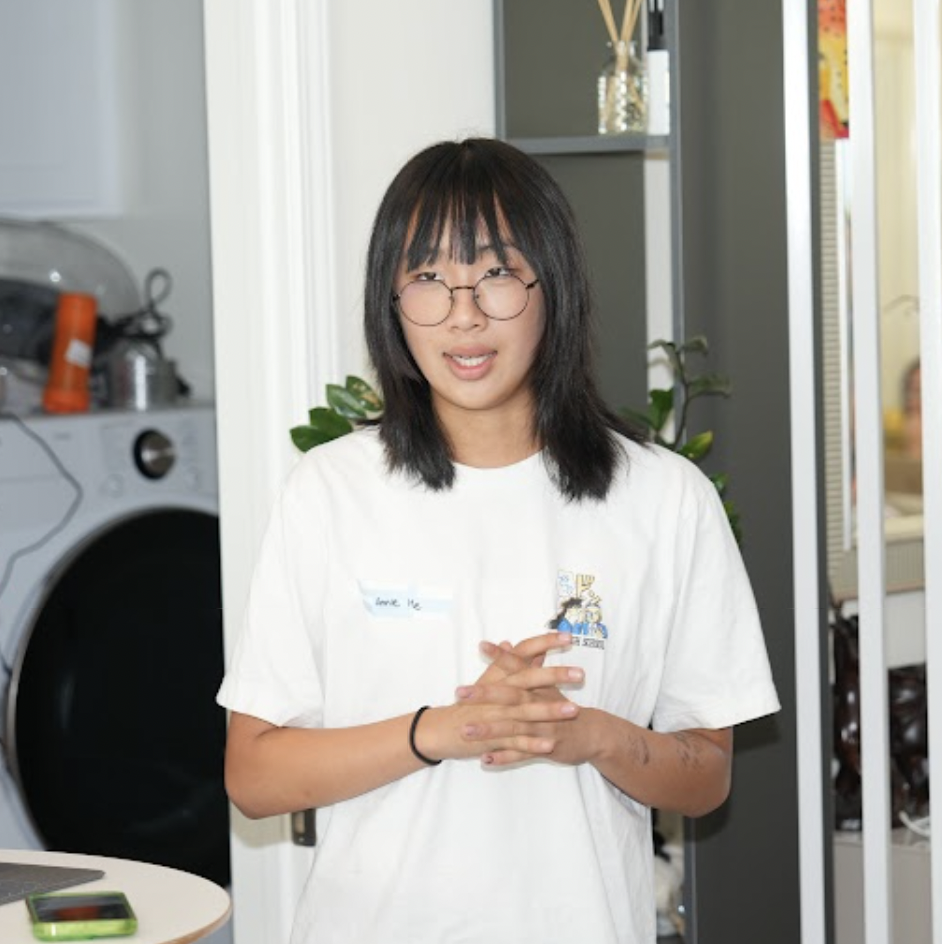 Person with glasses standing indoors near a laundry area.
