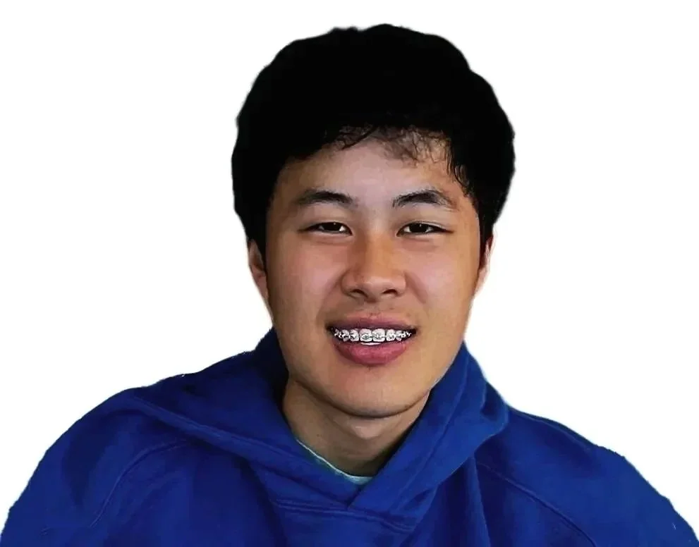 A young man smiling, wearing braces and a blue hoodie