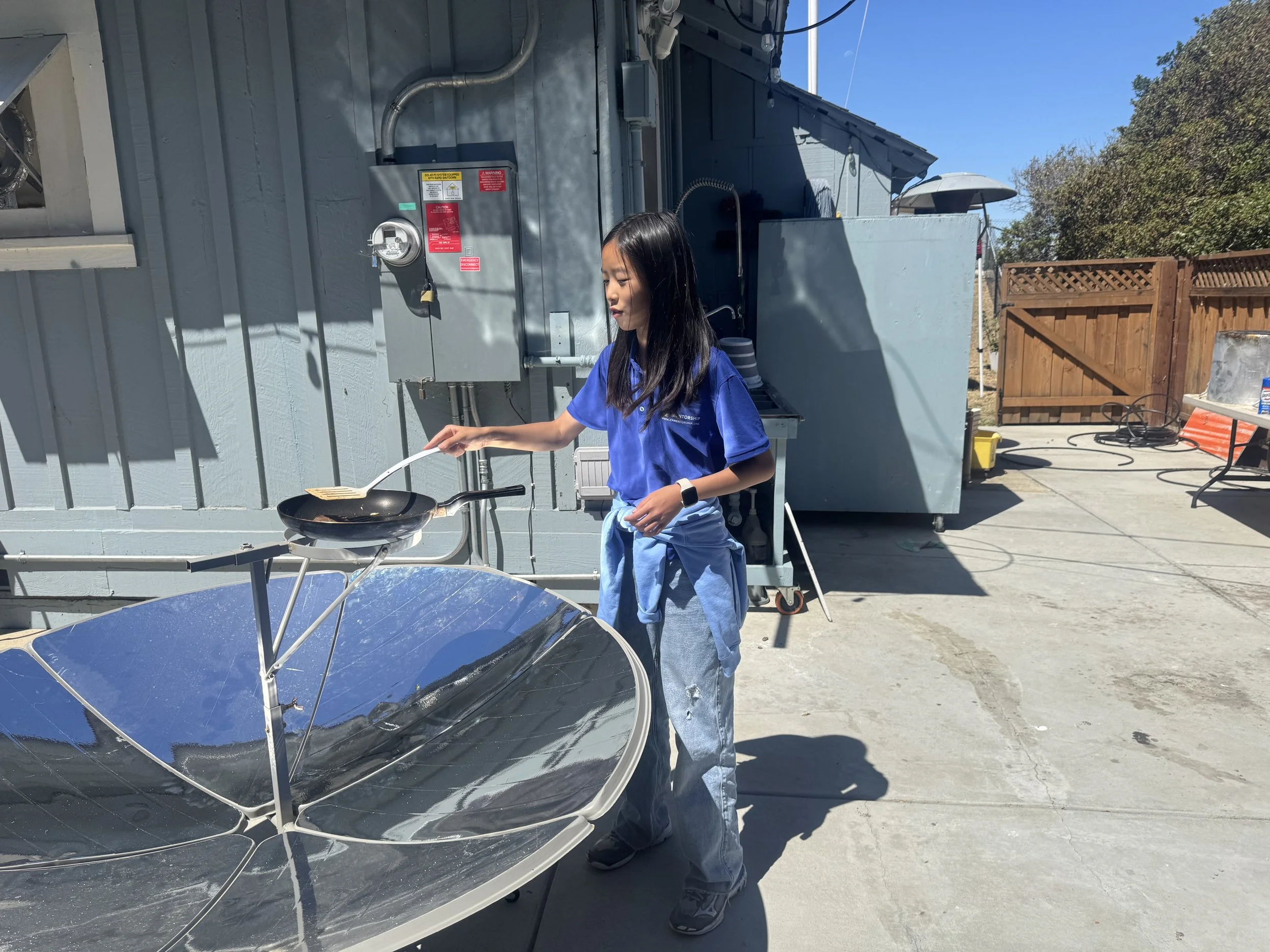  Camp Volunteer using parabolic solar cooker to cook the best steak you’ve ever had. 