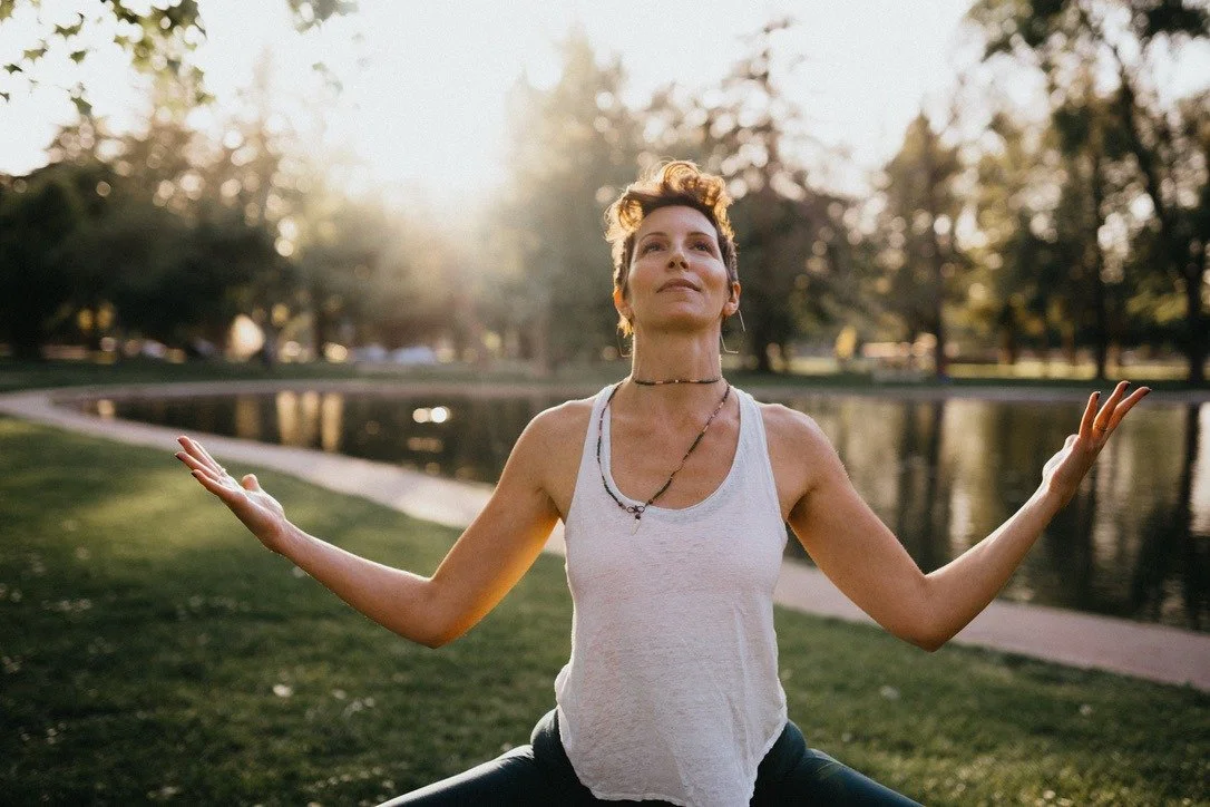 woman is sitting practicing yoga breathing in low sun outside