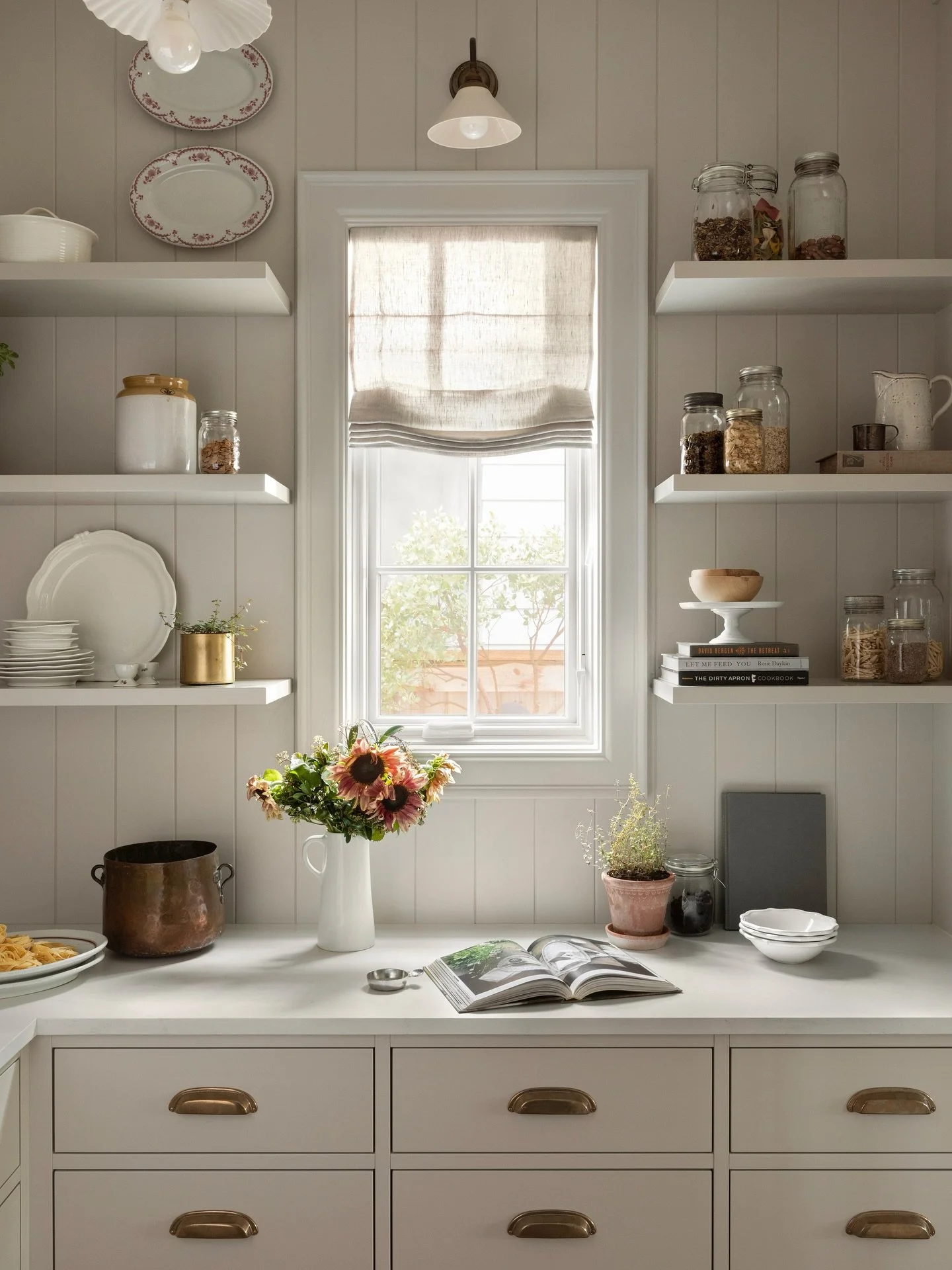 A truly hardworking pantry, where every detail balances utility with quiet elegance. One of @kimberlyjoneslifestyle &lsquo;s most enduring lessons is never to leave a window bare &mdash; frame it with a tree just beyond, so the view becomes an extens