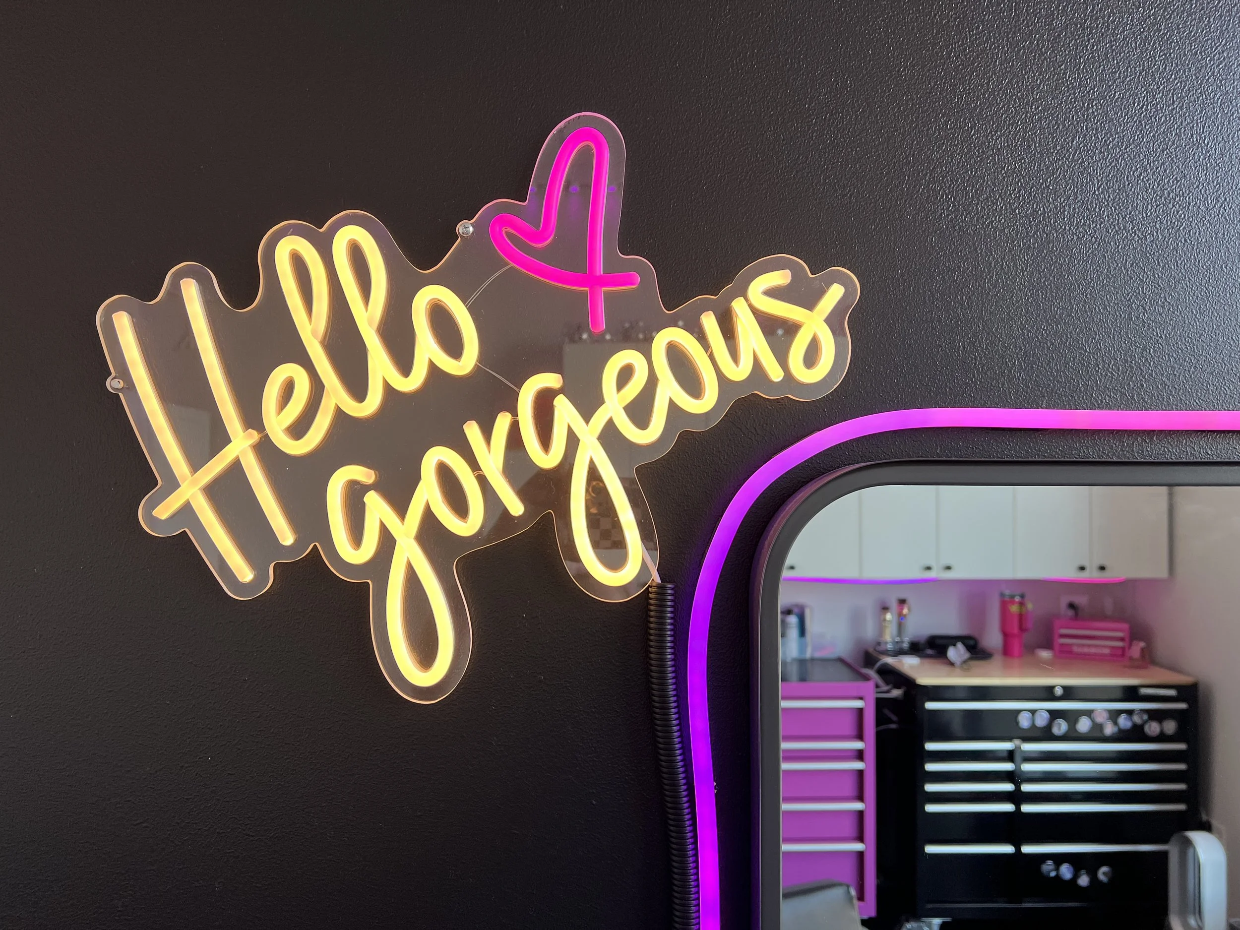 Photo of neon sign that says Hello Gorgeous with a neon pink heart. Salon located in Northwest Davenport, Iowa. This salon offers haircuts and colors.