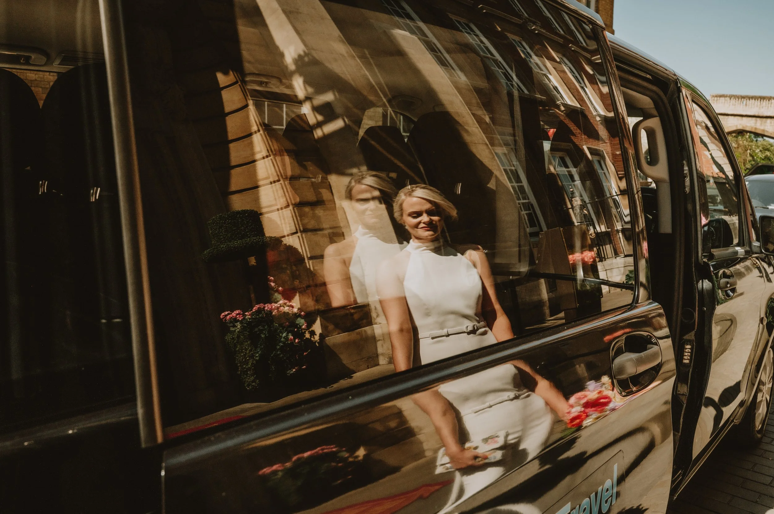 Reflection of a beautiful bride in a taxi window in York, captured by Jules Williams Photography
