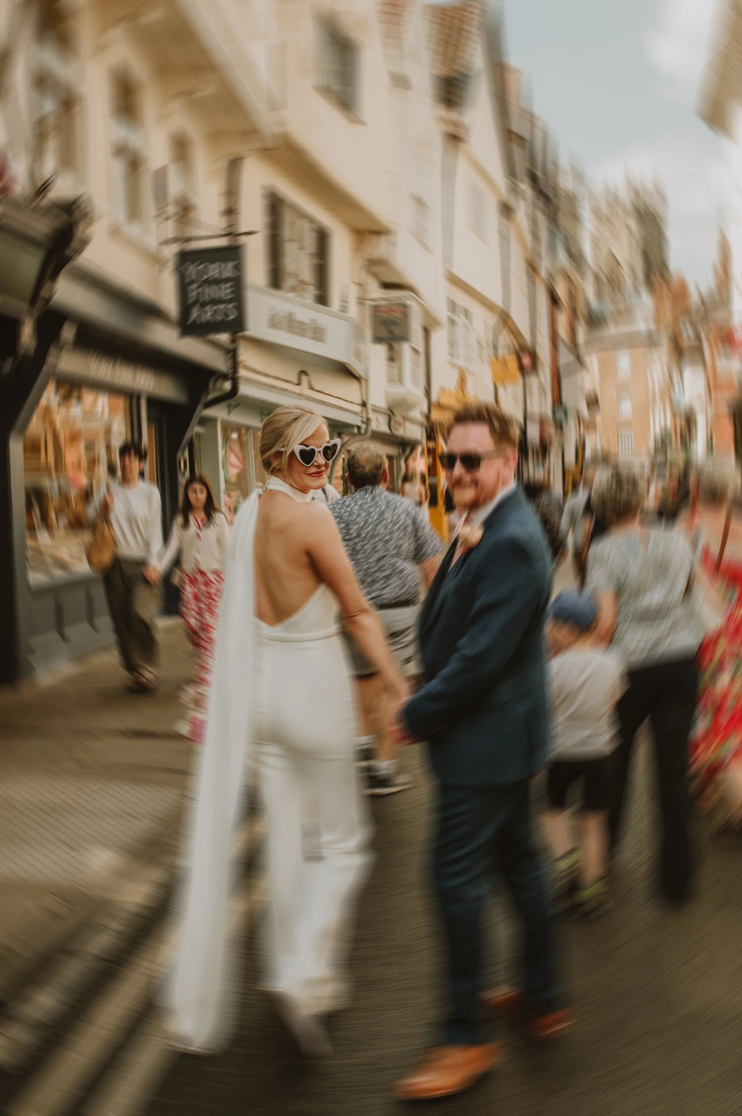 Motion blur image of bride and groom walking through York, captured by Jules Williams Photography