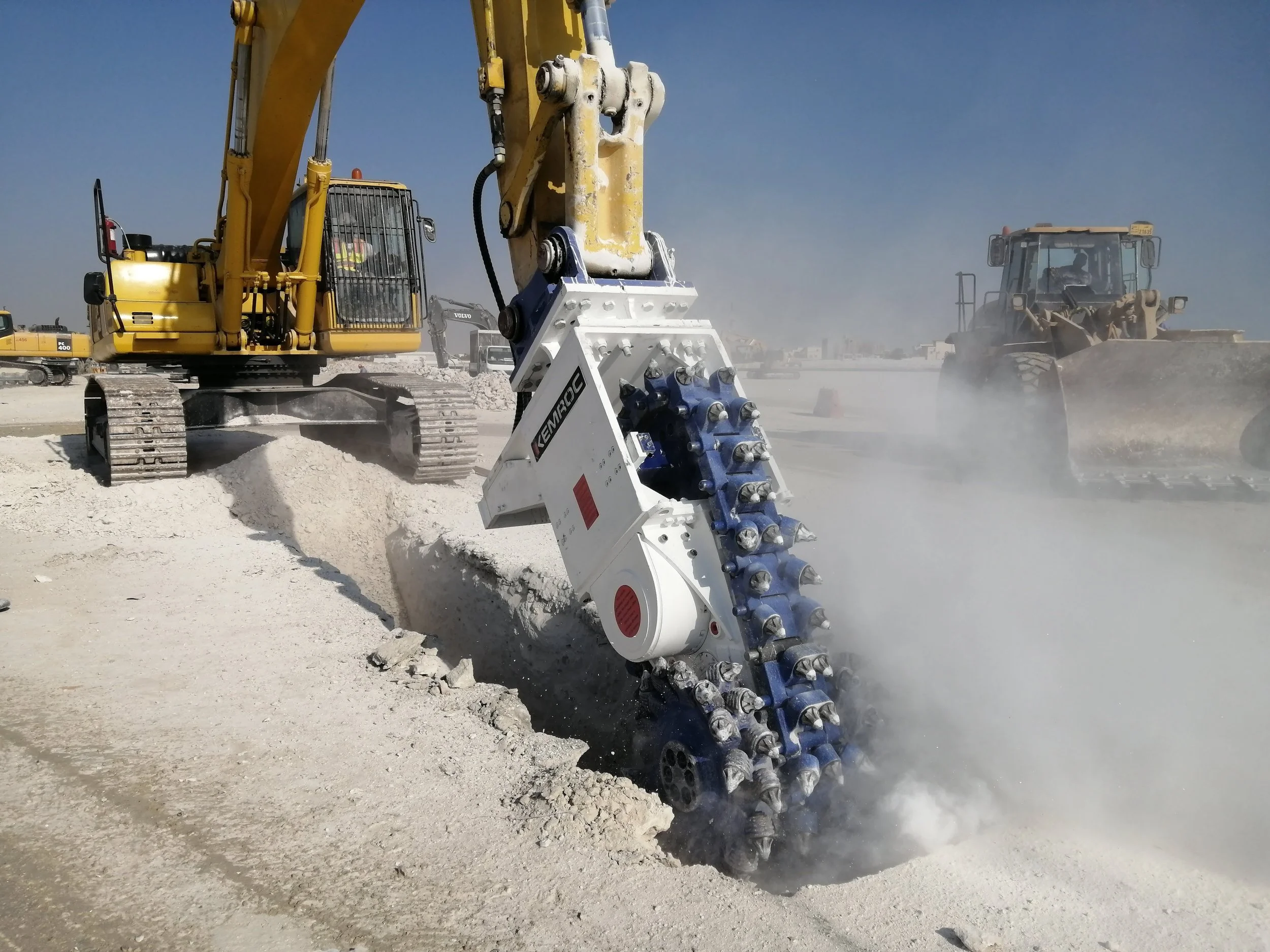 An image of a excavator attachment trenching rock ground