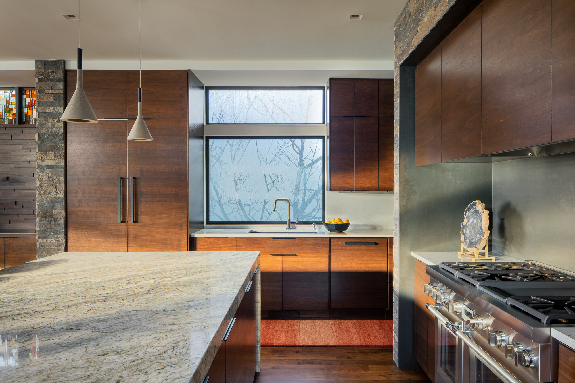 Beautiful light splashes across this modern kitchen in this architectural photo