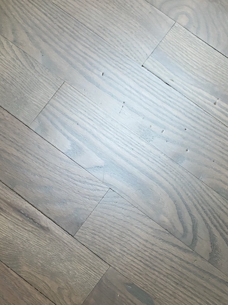 Close-up of light-colored wooden floorboards with visible grain patterns.