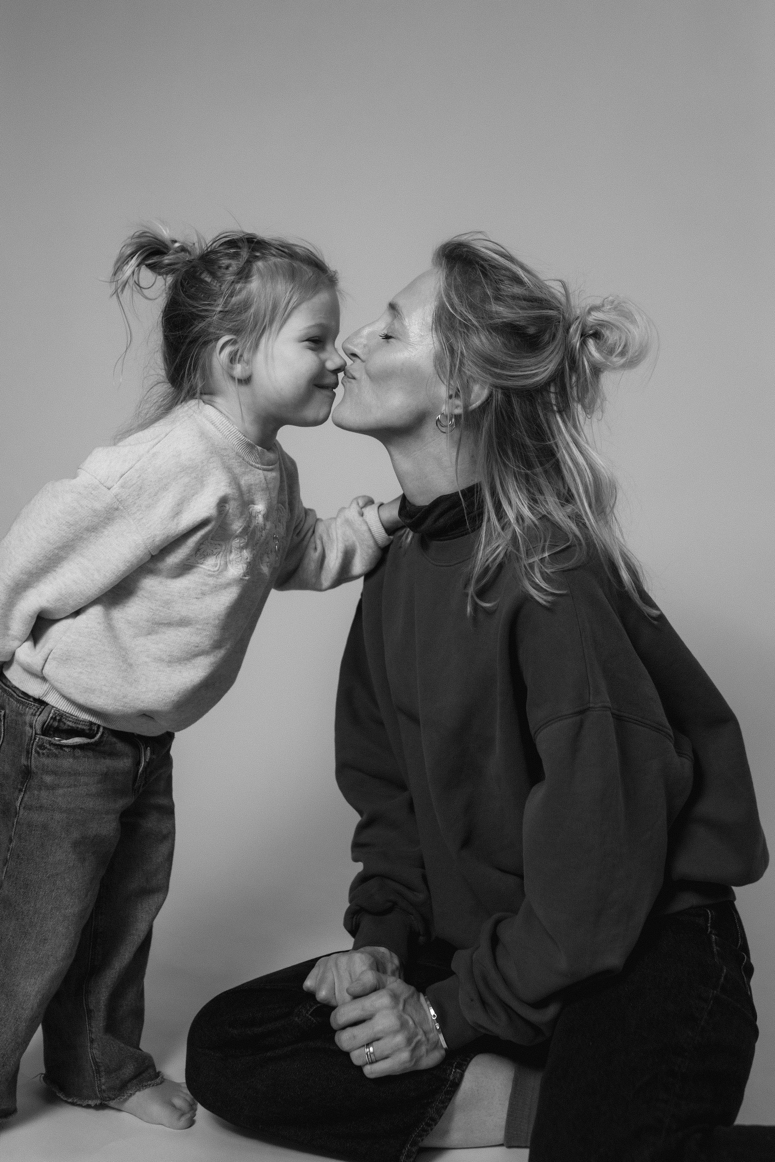 Studiofoto van een mama met haar dochter in zwart-wit.