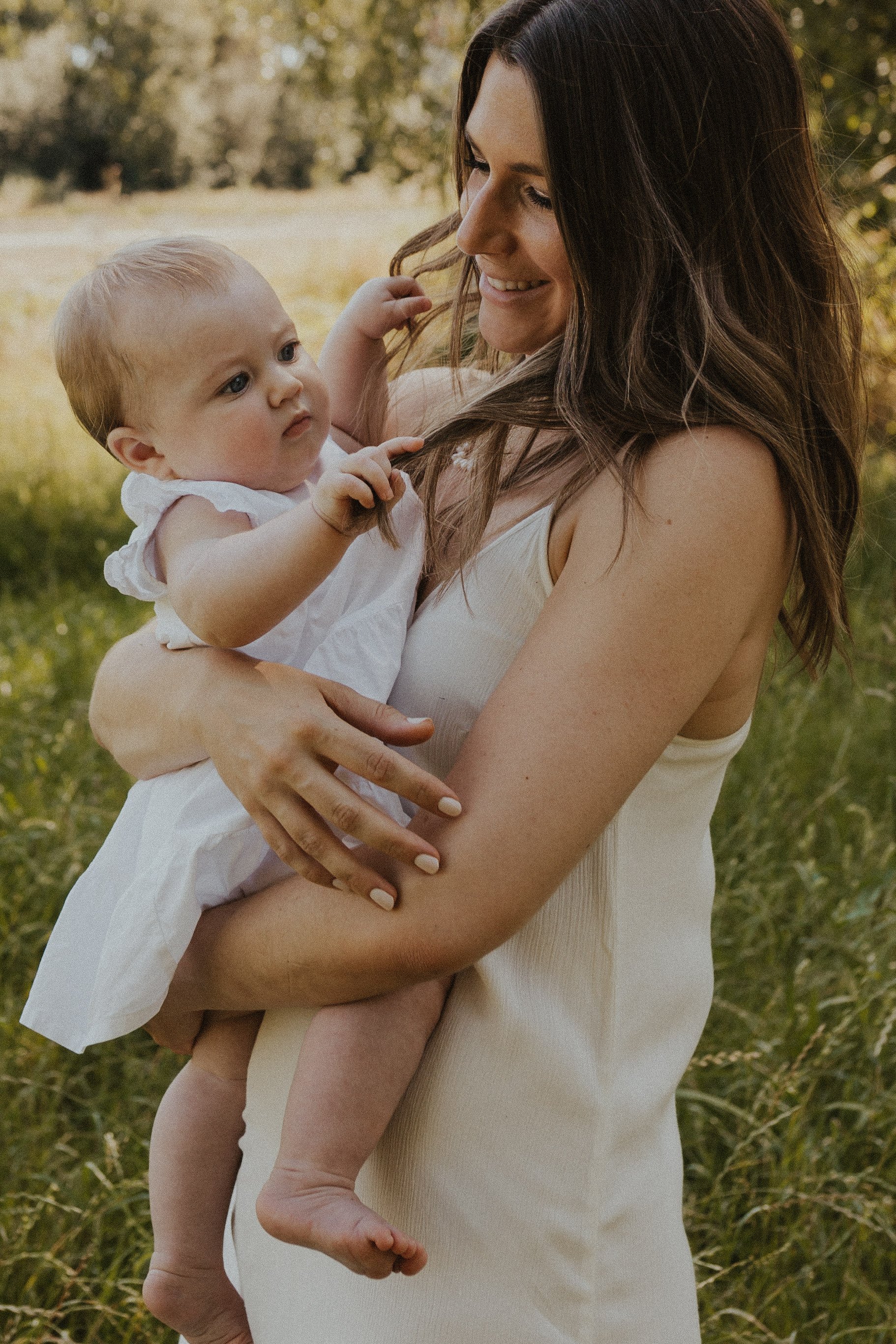 Een portret van een mama met haar baby meisje in een weiland in Balen