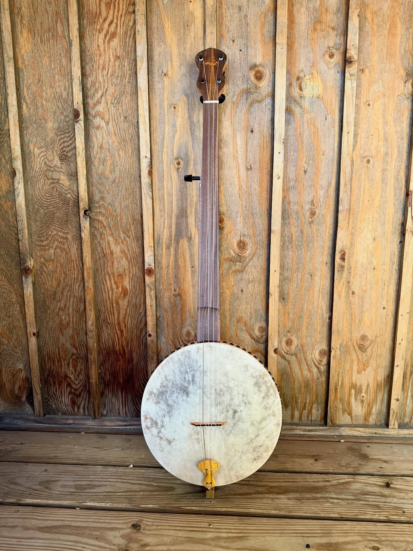 Commission tackhead!  Cherry neck, 12 inch pot, and walnut overlays. The tailpiece is a chunk of Osage orange.