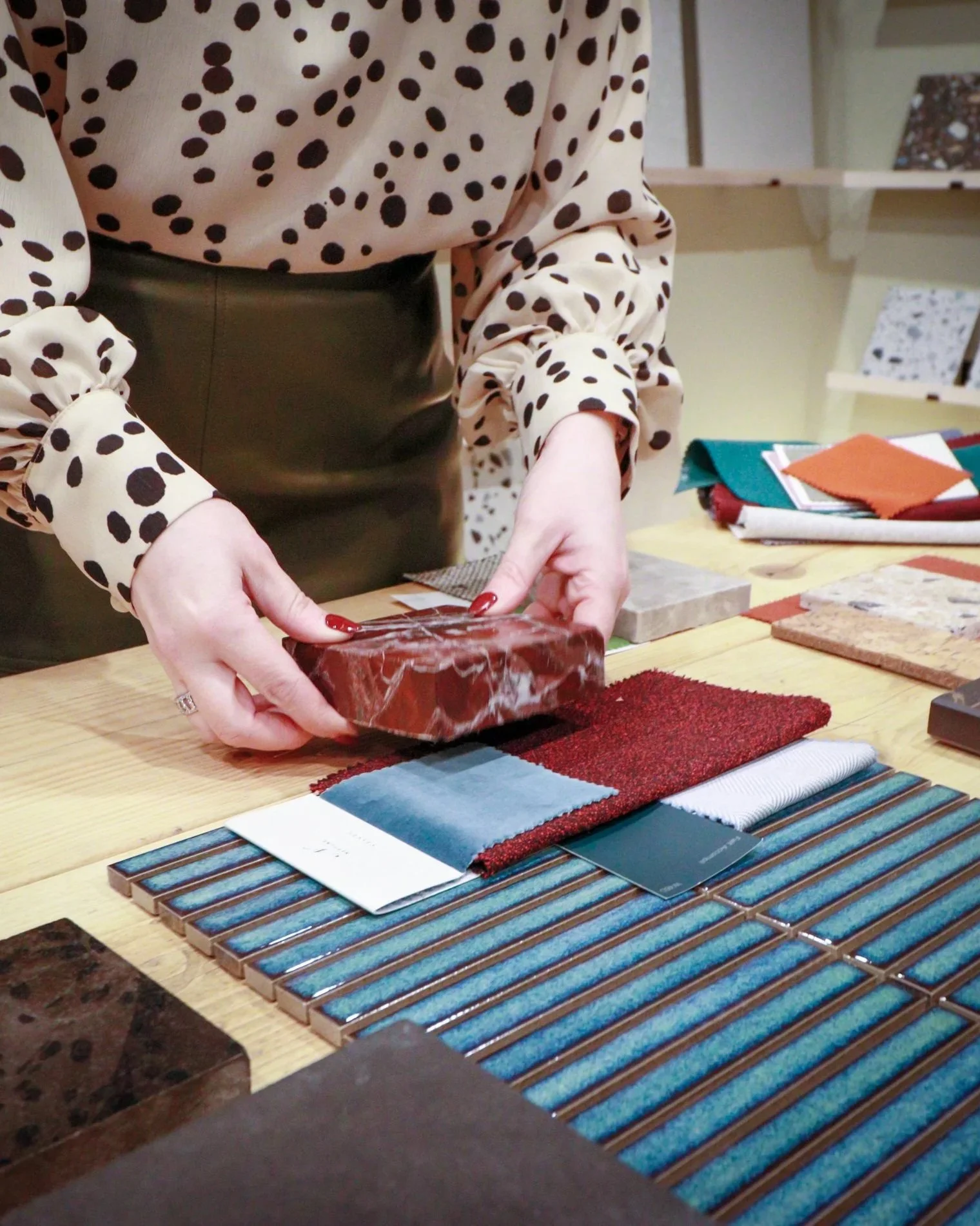 Person handling samples of tiles, paint strips and textile materials