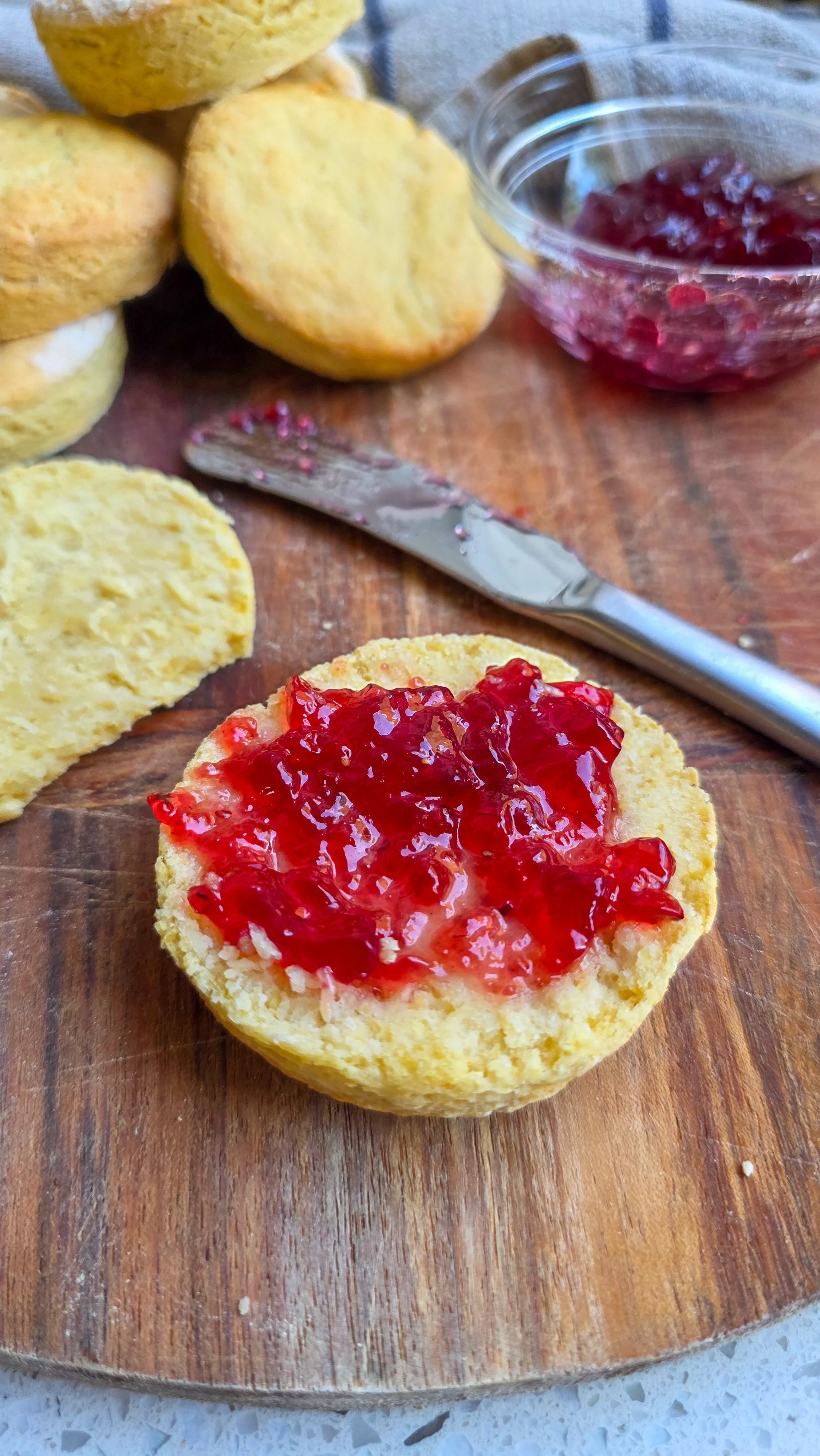 Vegan scones on a chopping board with jam