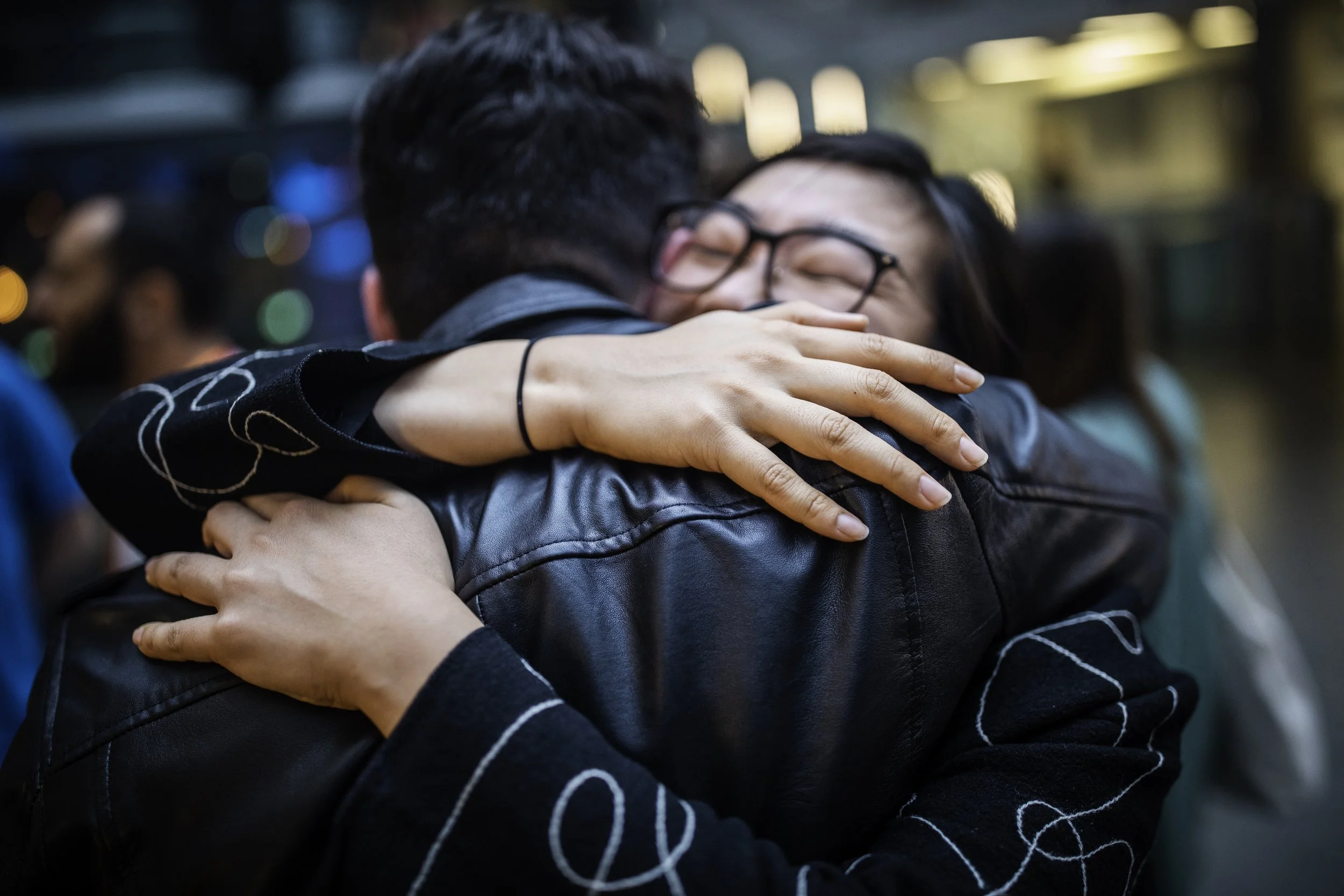 Two festival attendees greet each other with a joyous hug