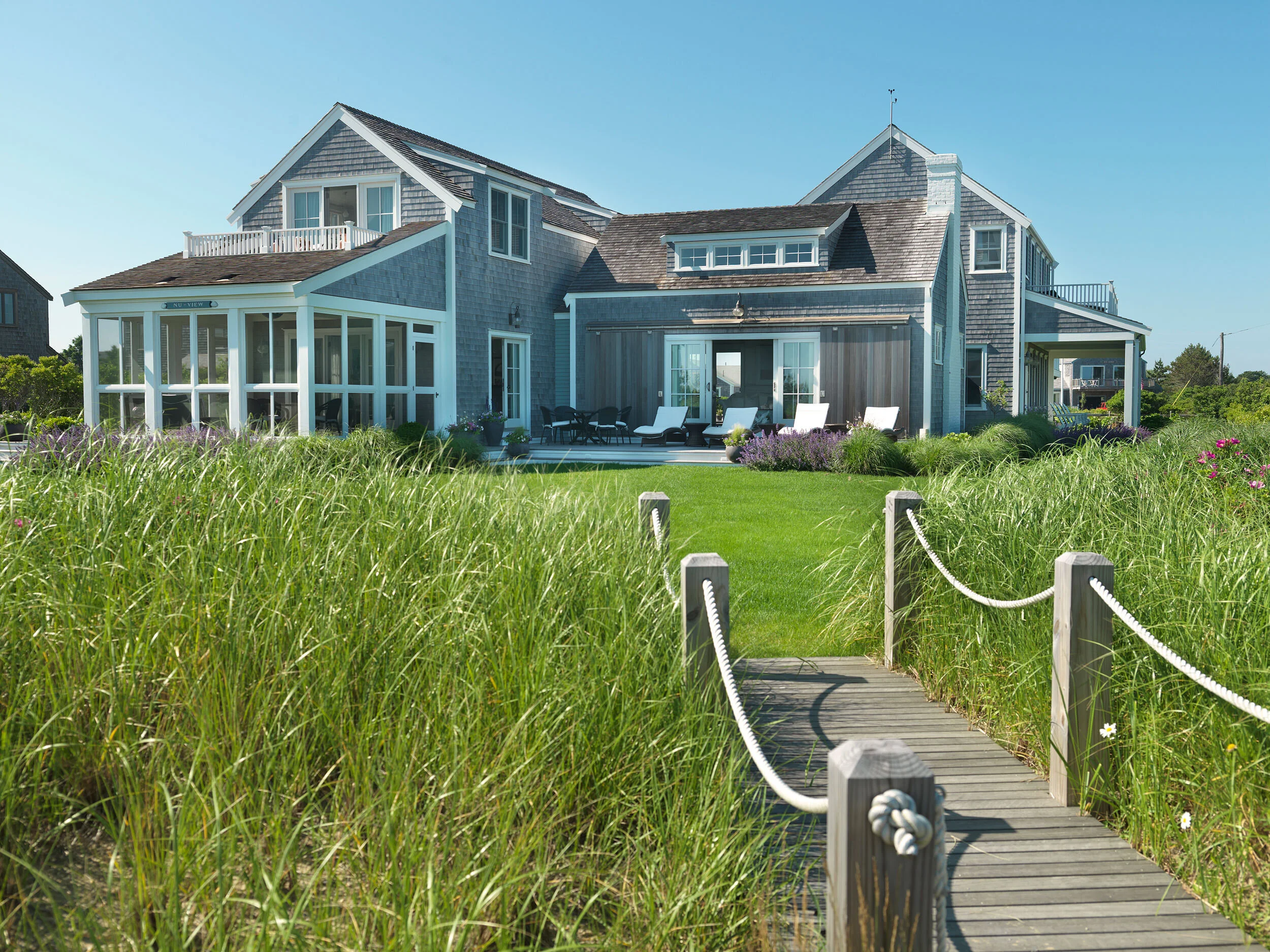 The exterior of Nantucket Home with Wooden Pathway to the Beach