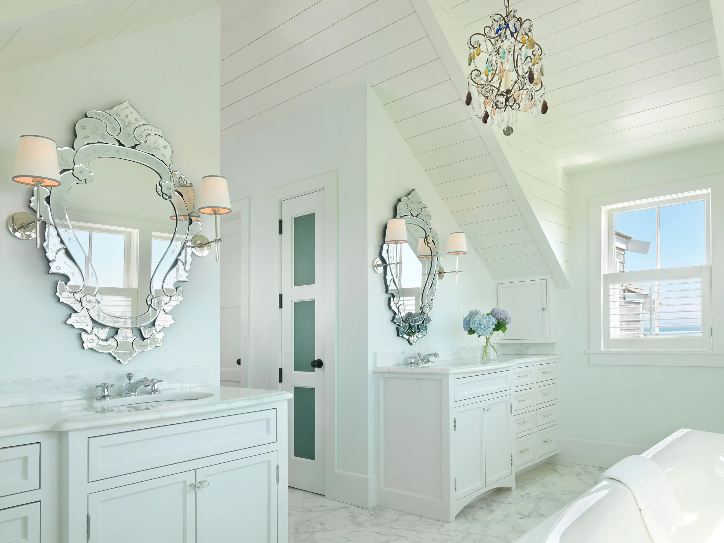 White Master Bathroom with Chandelier, Soaking Tub, and Shiplap in Nantucket Home