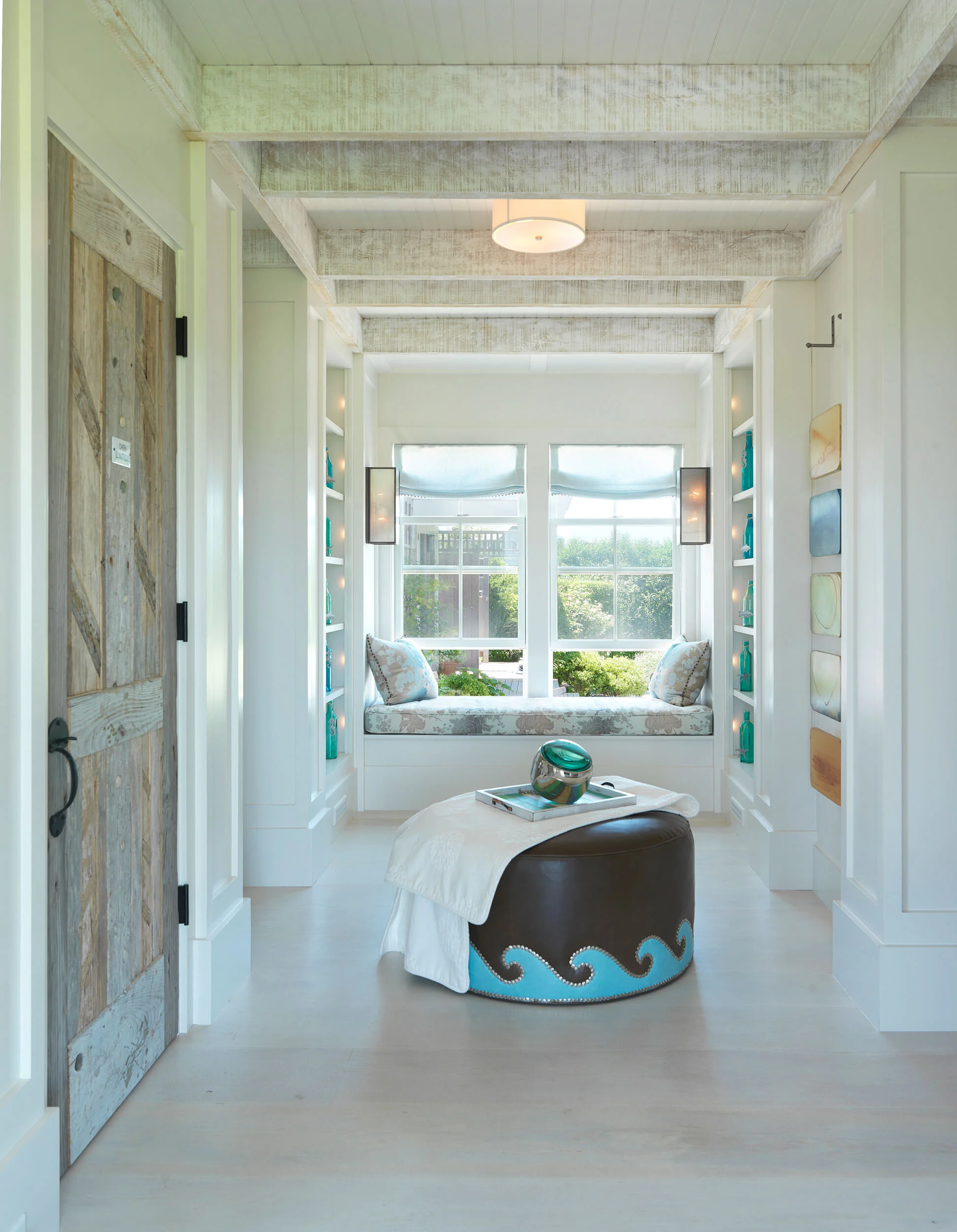 Colorful Hallway with Exposed Beams, Leather Ottoman, Farm Door, and Window Seat of Nantucket Home