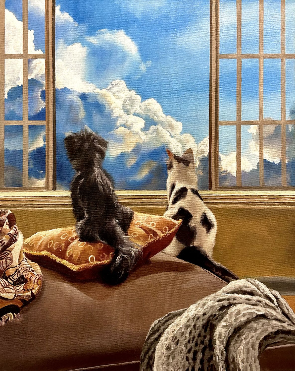 Two dogs, one black and one white with black spots, sitting on a cushion and looking out of an open window at a bright blue sky with fluffy clouds.