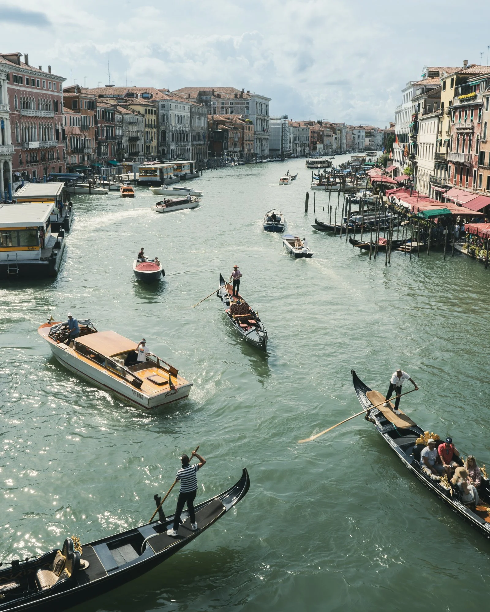Gondolas on a canal in Venice, Italy, with boats and buildings lining the waterway.