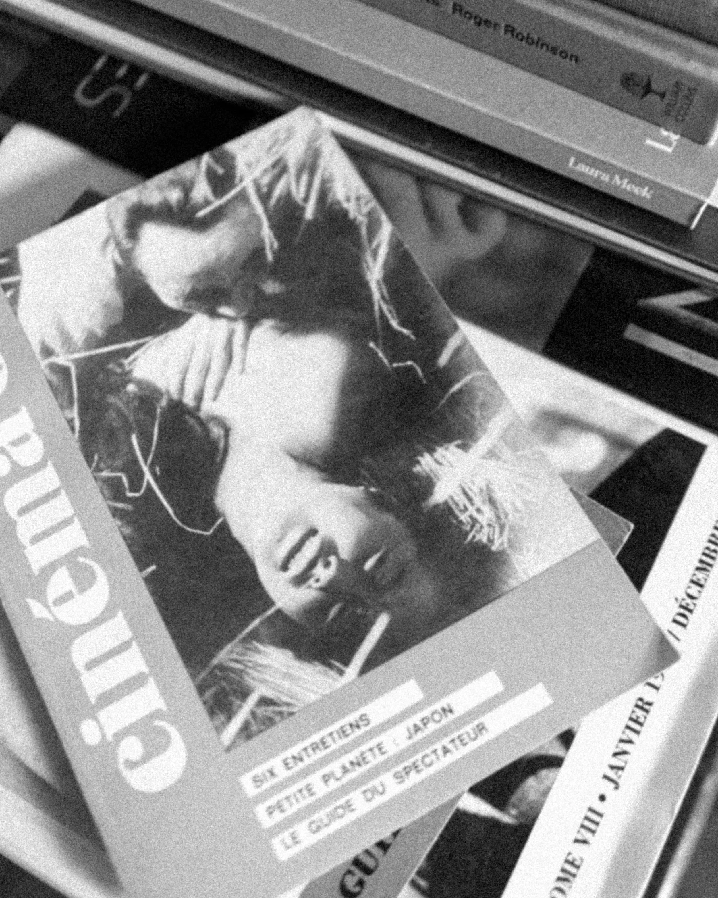 Close-up black-and-white photo of a magazine or newspaper with text and a picture of a woman and a man. The text includes the words 'GUEST' and 'ROGER ROLBINSON.' The photo is slightly blurred and difficult to interpret fully.