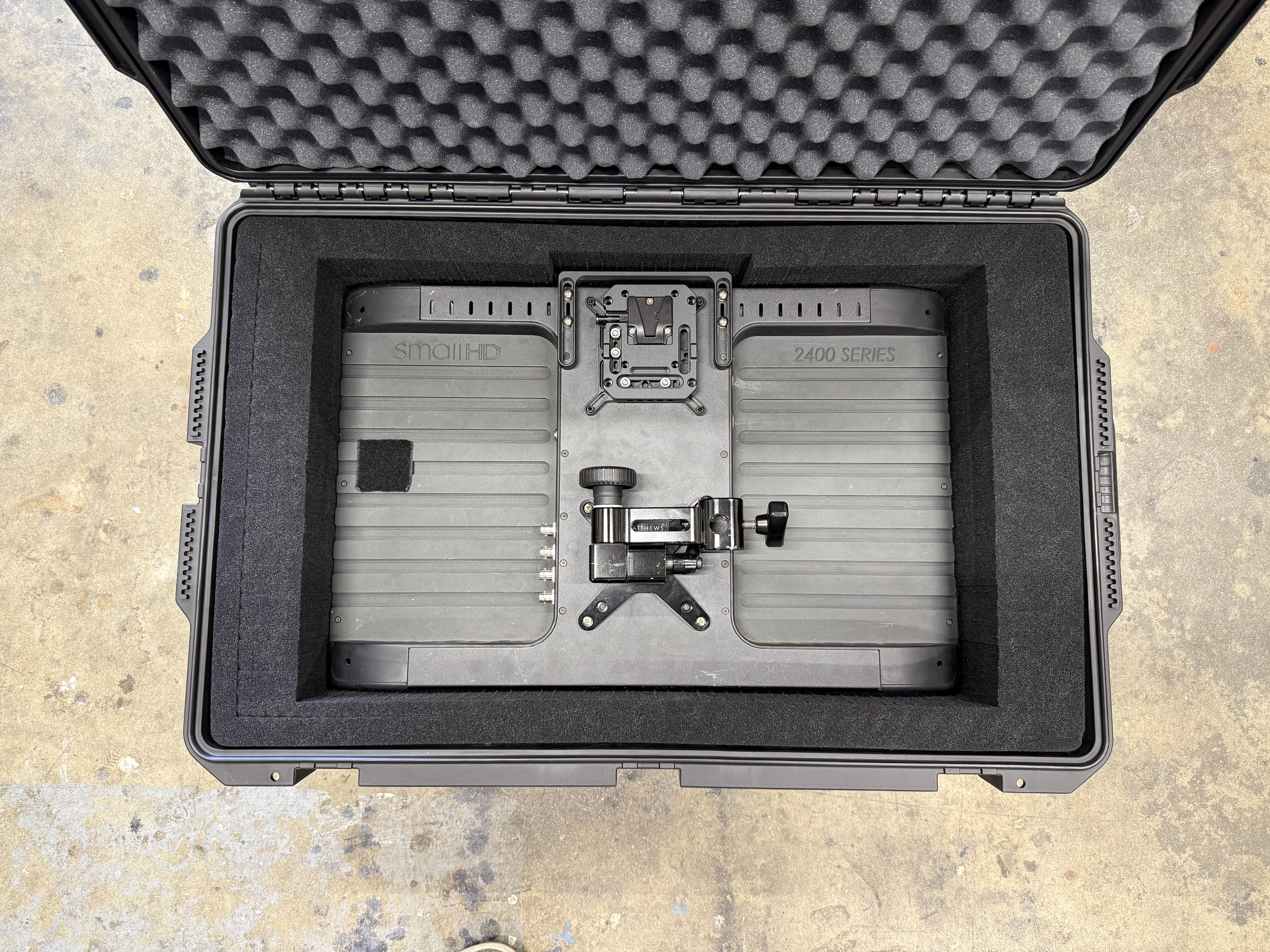 A black hard protective case with foam padding, containing a large flat gray metallic drone with the label 'small H150S 2400 SERIES' and a mount bracket attached.