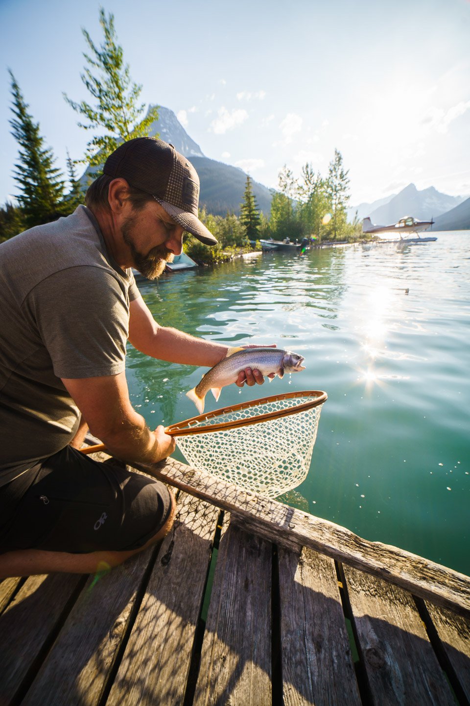 guy holding fish at dock