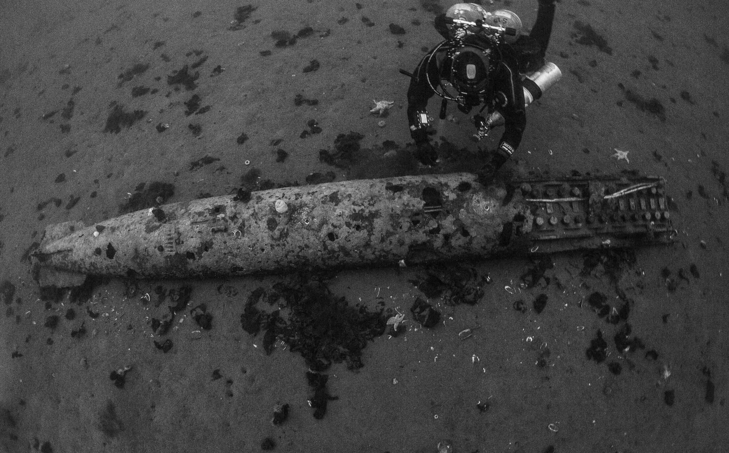 John Copeland poses next to an unexploded German torpedo that missed its target in 170'
