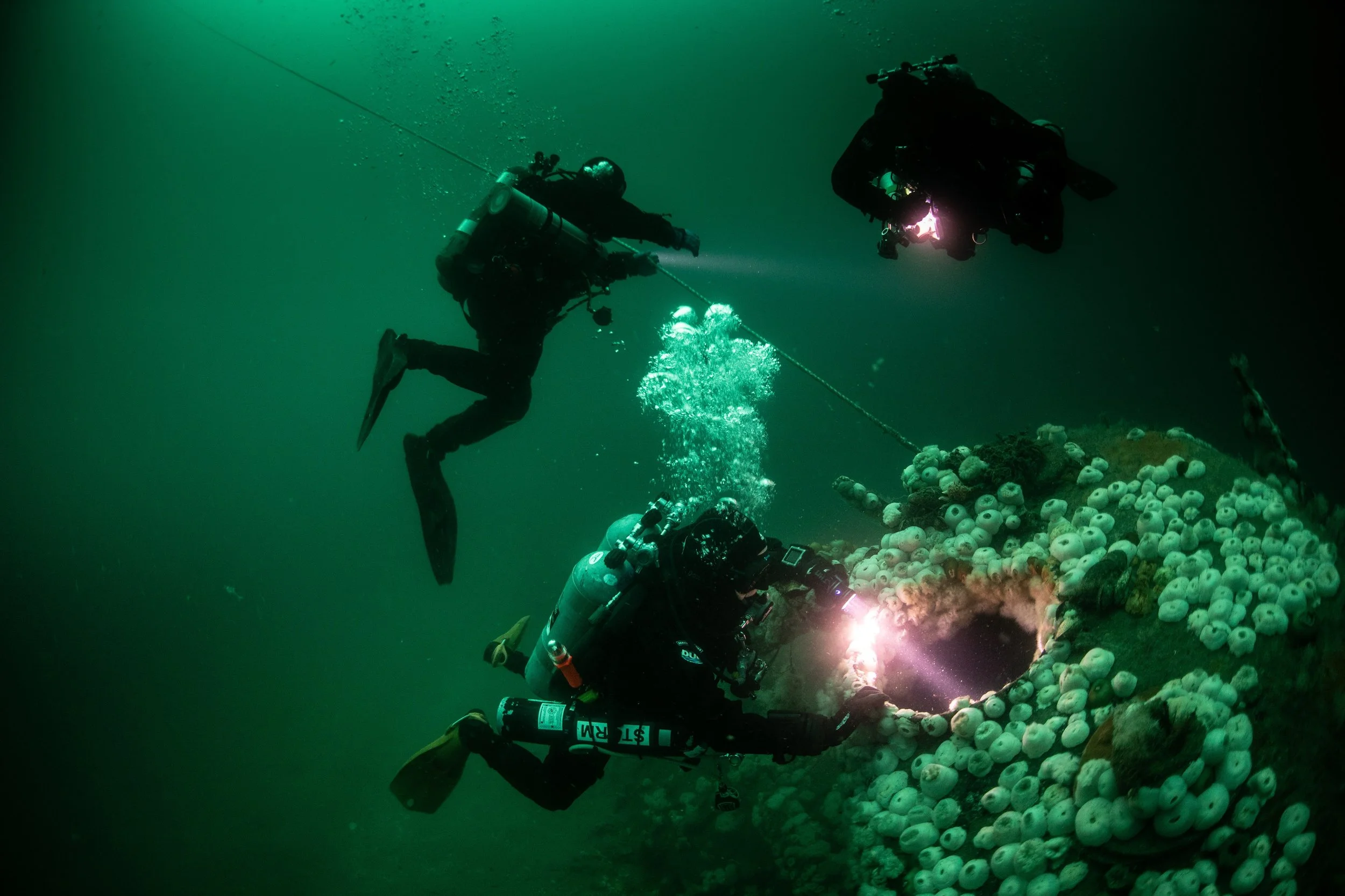 Divers peer into the conning tower of the S5 Submarine.