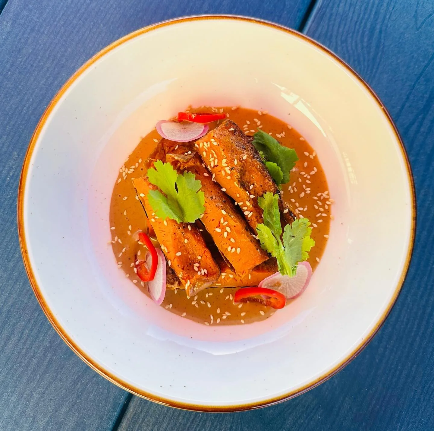 Vegetarian special alert! 
This is a roasted honeynut squash atop a rich sauce of blackened koji molé. The sauce is blended with butter to emulsify and is very decadent. It gets garnished with pickled fresno, sesame seeds, radish, cilantro, a