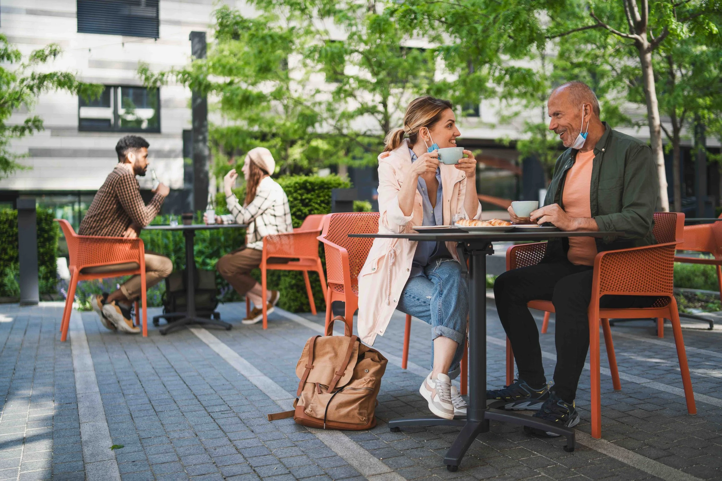 Photo of friends enjoying coffee at a coffee shop's outdoor seating.