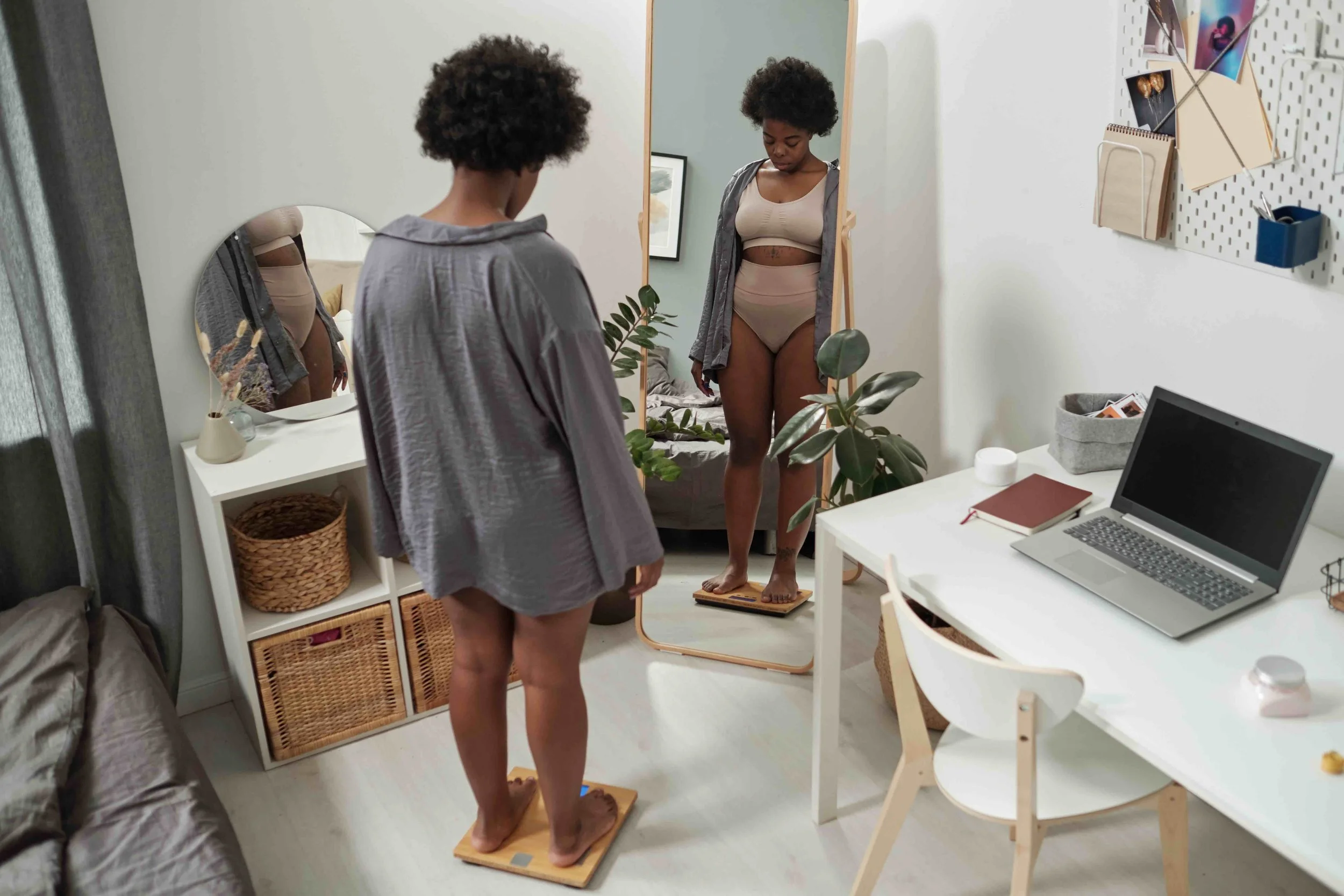 Photo of a woman measuring weight loss success on scales.