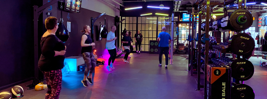 Coach guiding small group strength training session at Megabox Fitness