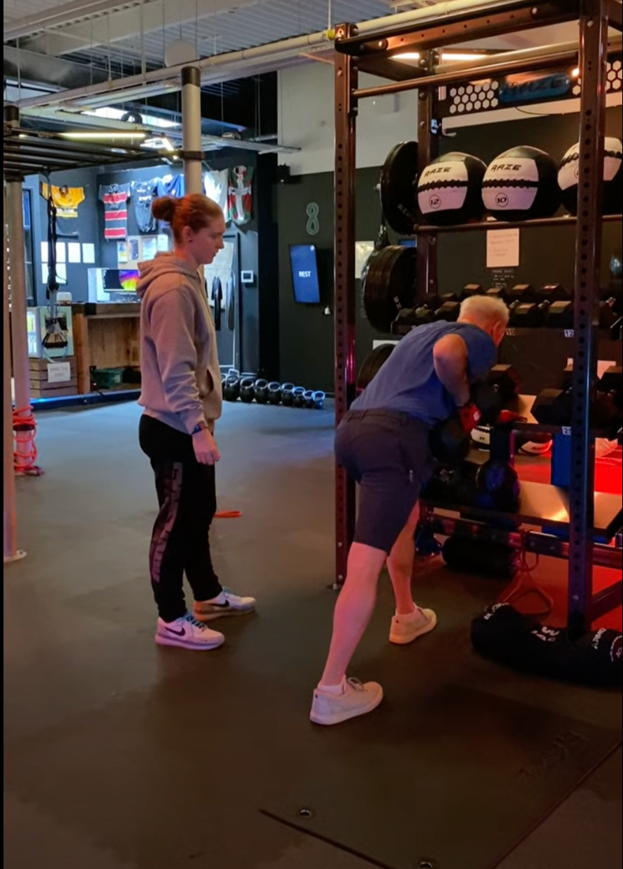 Coach guiding a personal training client