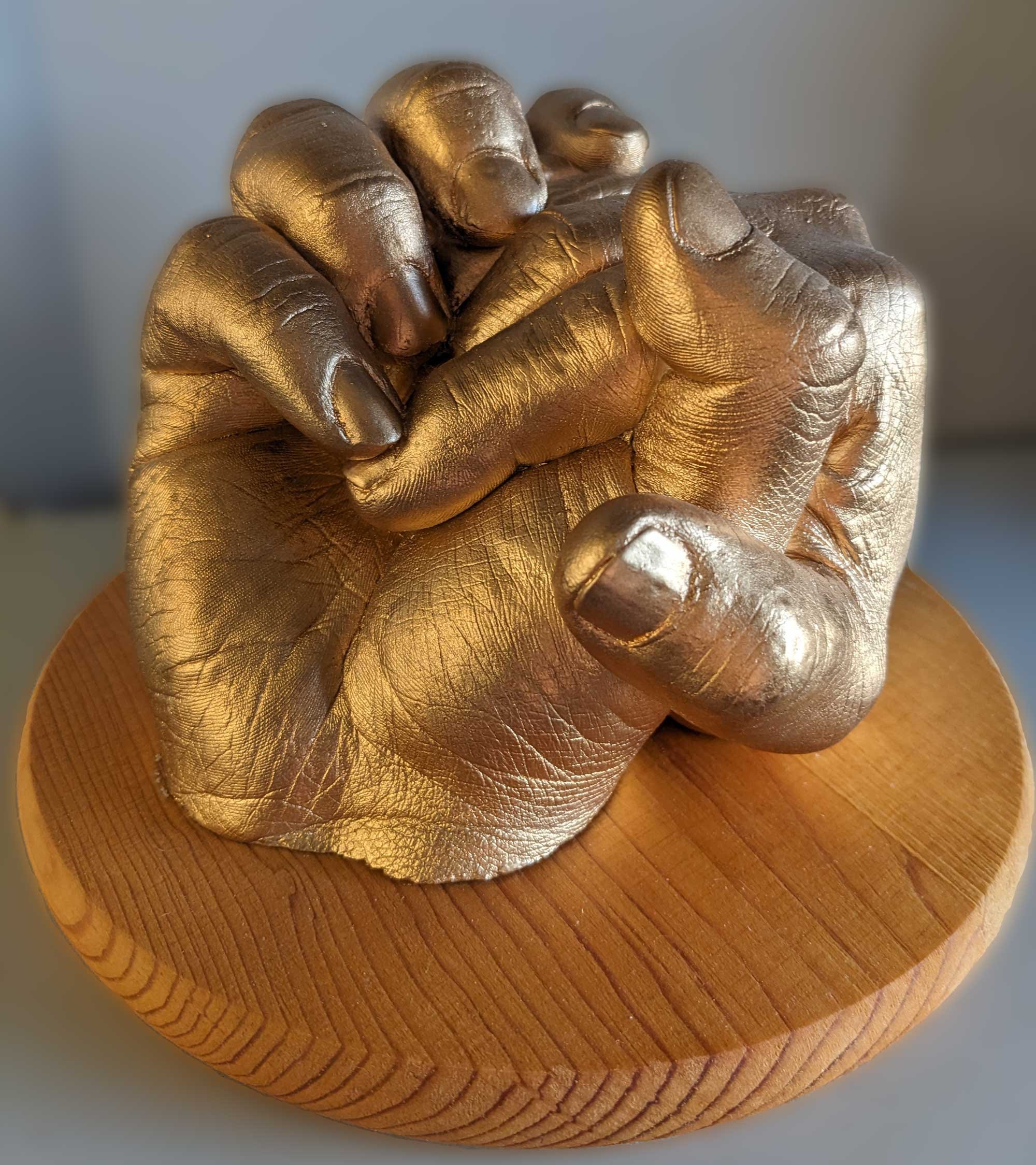 Casting of 2 hands holding in gold