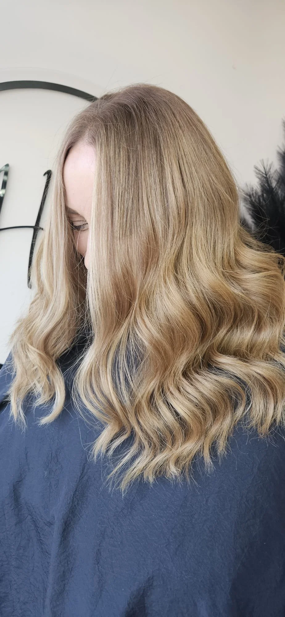 Woman with blonde, wavy hair in a salon