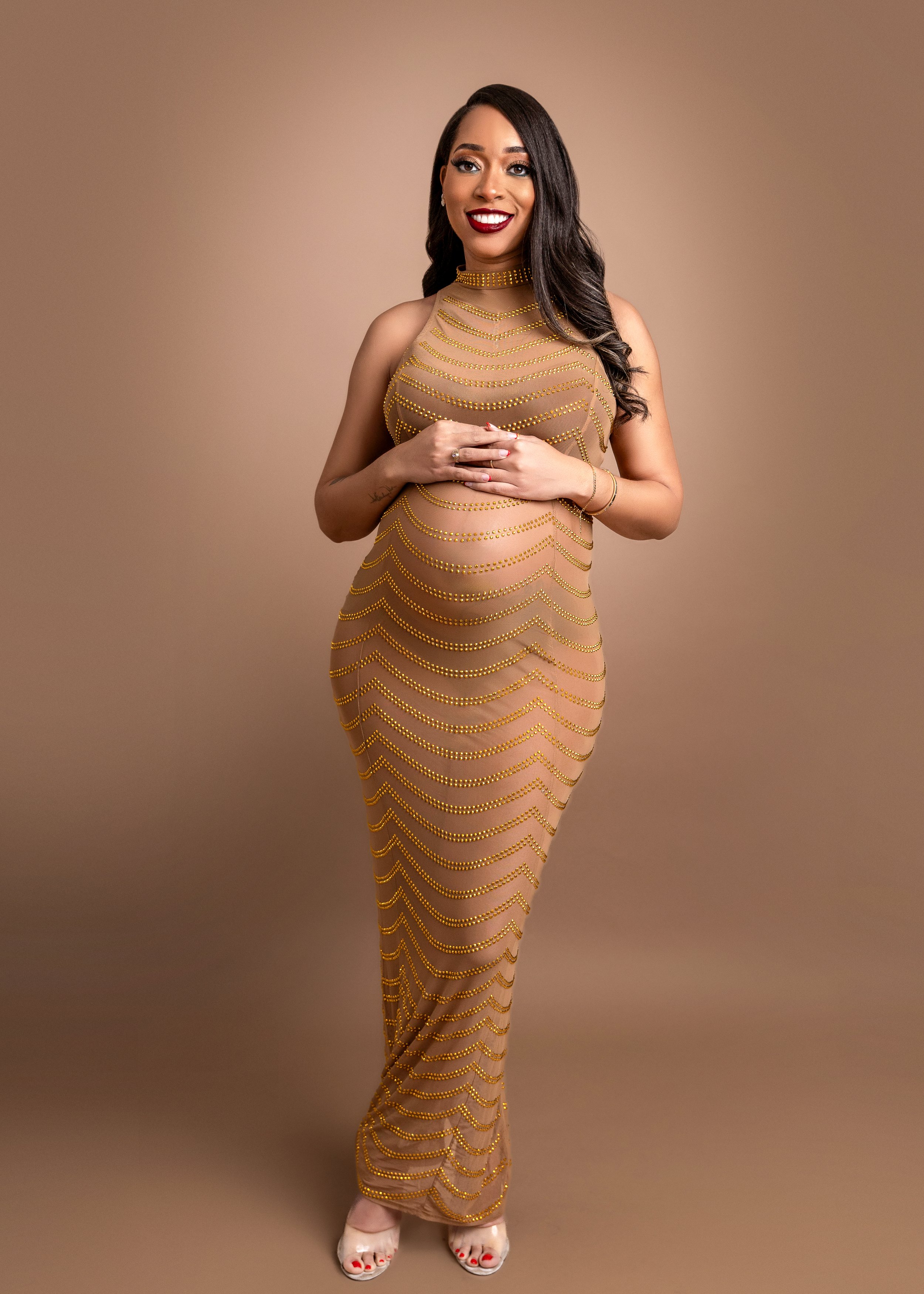 Maternity photo of mom to be smiling and holding her belly