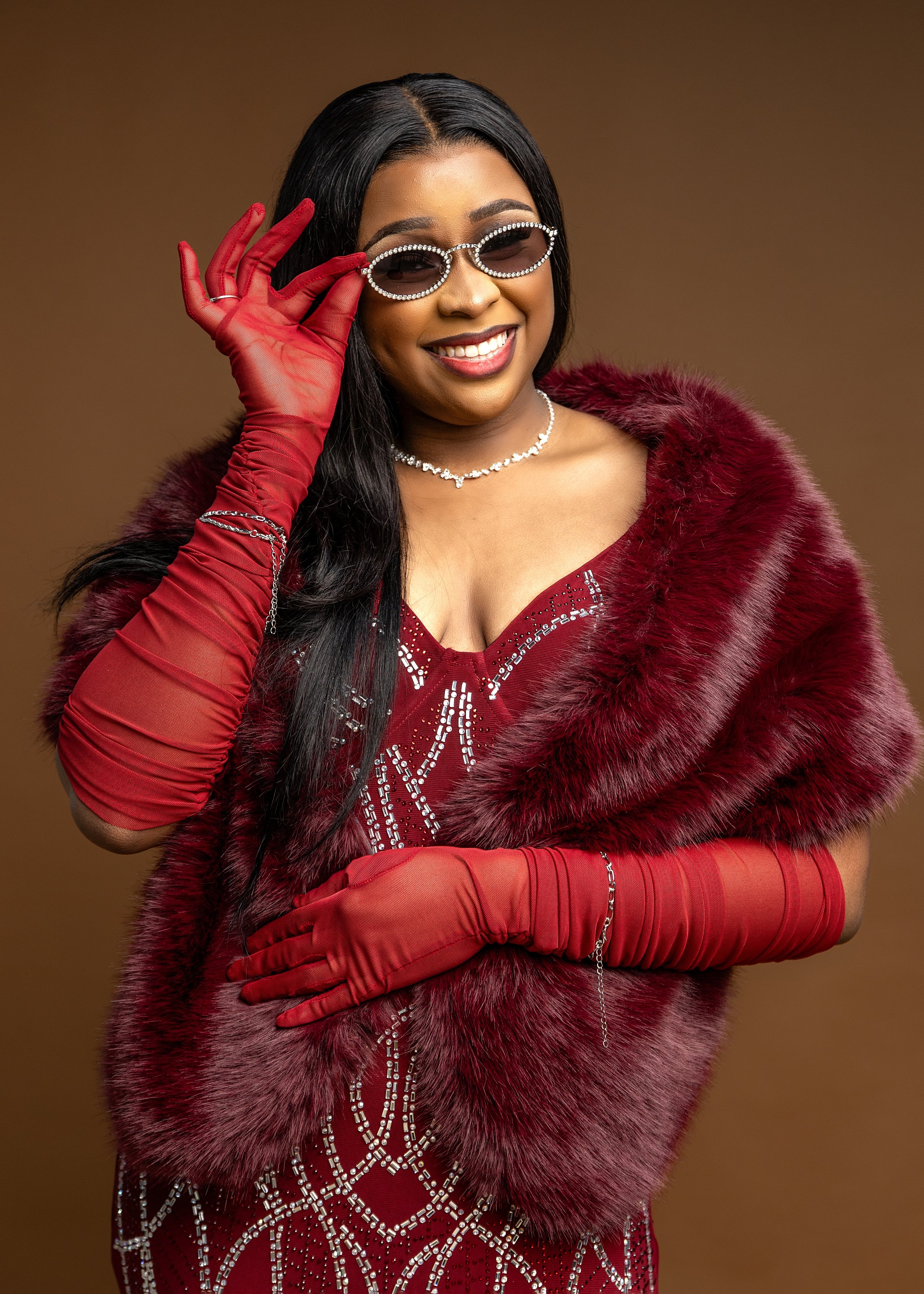 Portrait of woman with red fur coat, red dress, red gloves and sunglasses