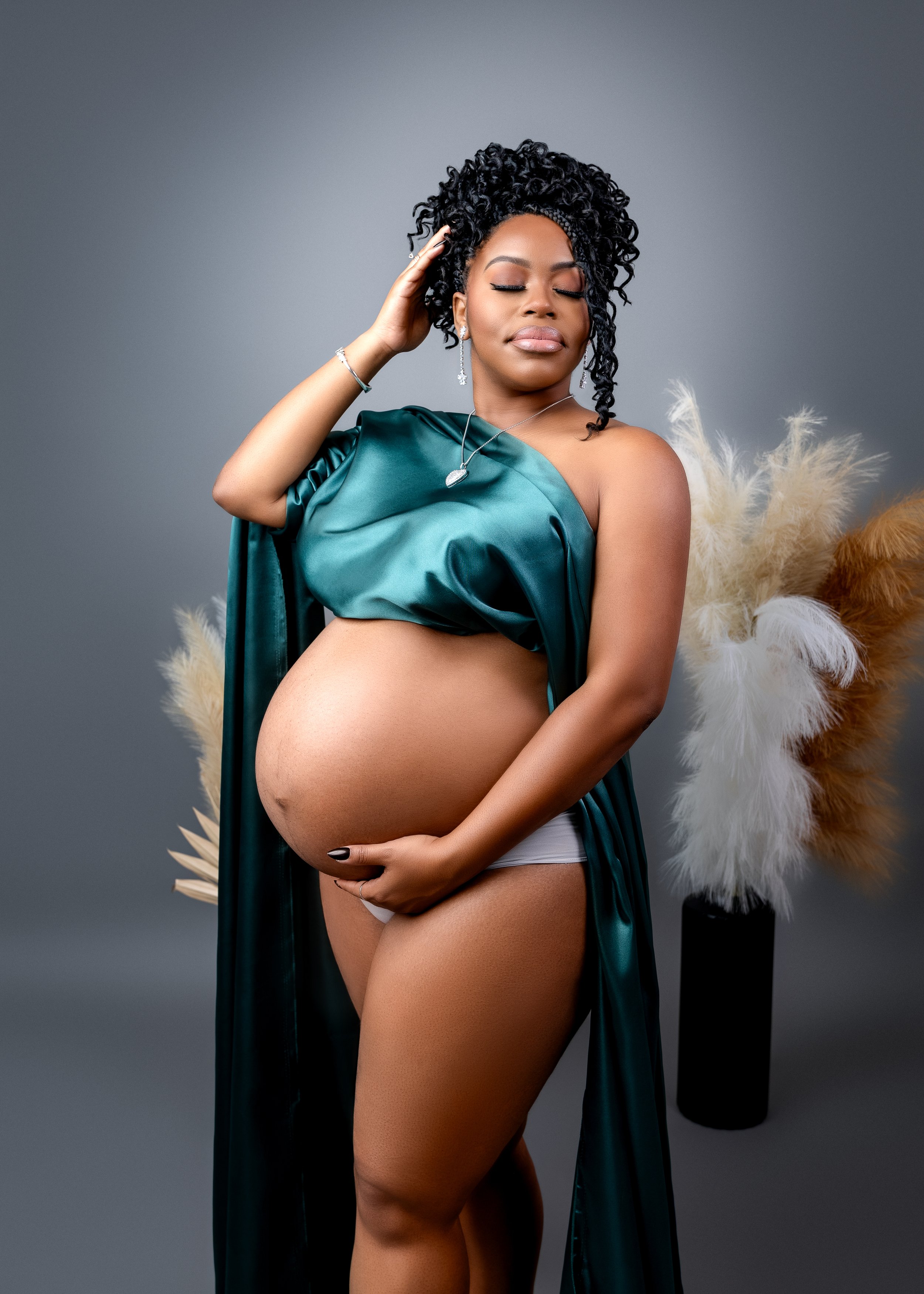 Maternity photo of mom to be with a green fabric draping over her