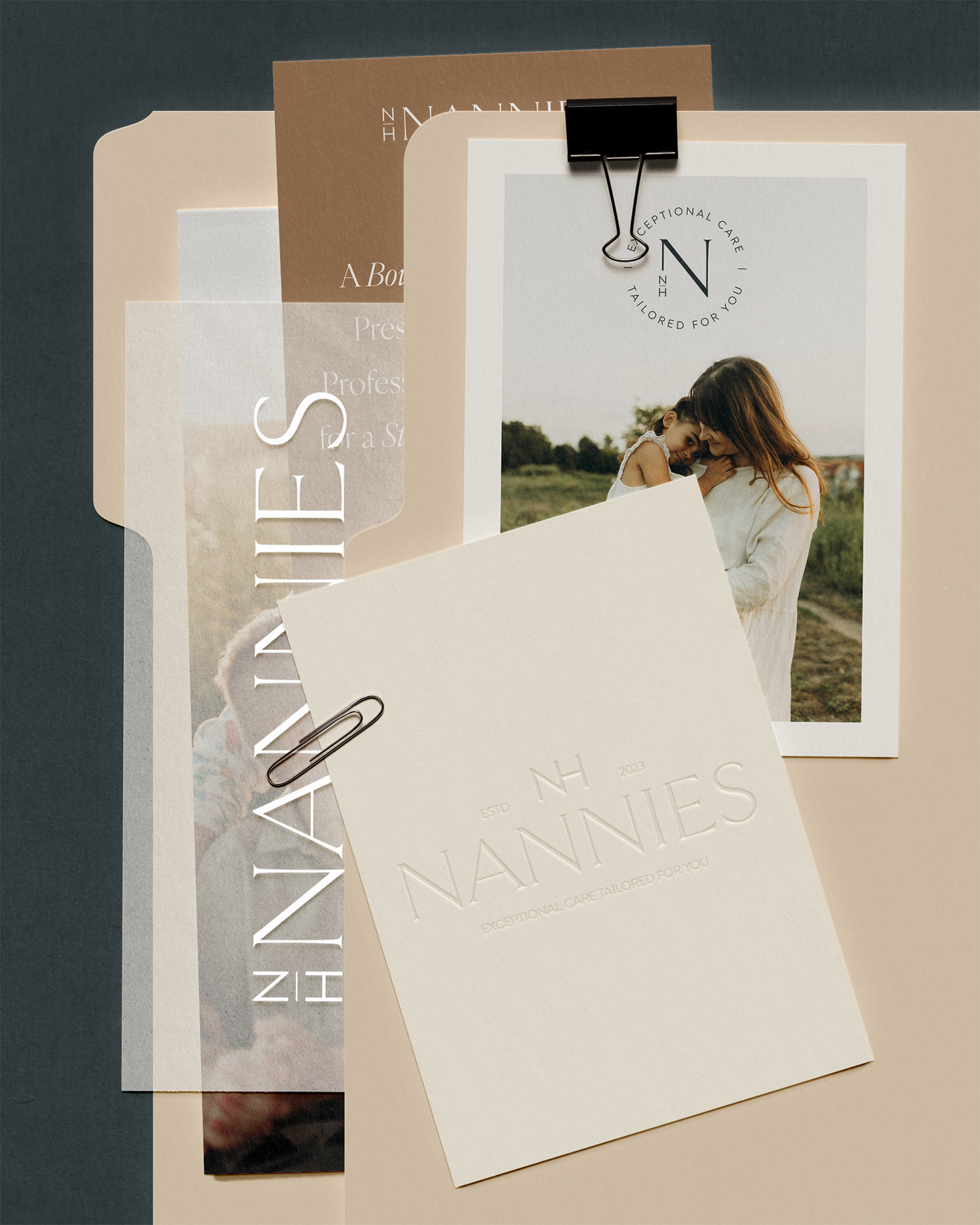 Multiple sheets of paper, a photograph of a woman and a girl, black binder clip, and printed text for a branding or marketing project related to 'NANNIES' and exceptional care.